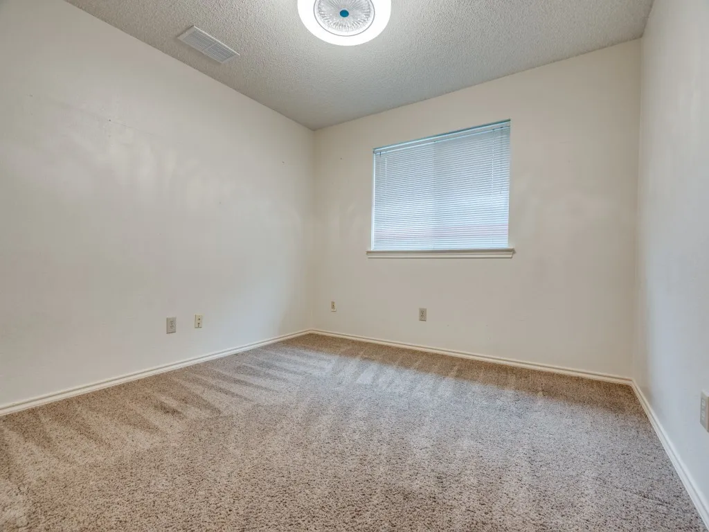 Carpeted empty room with a textured ceiling