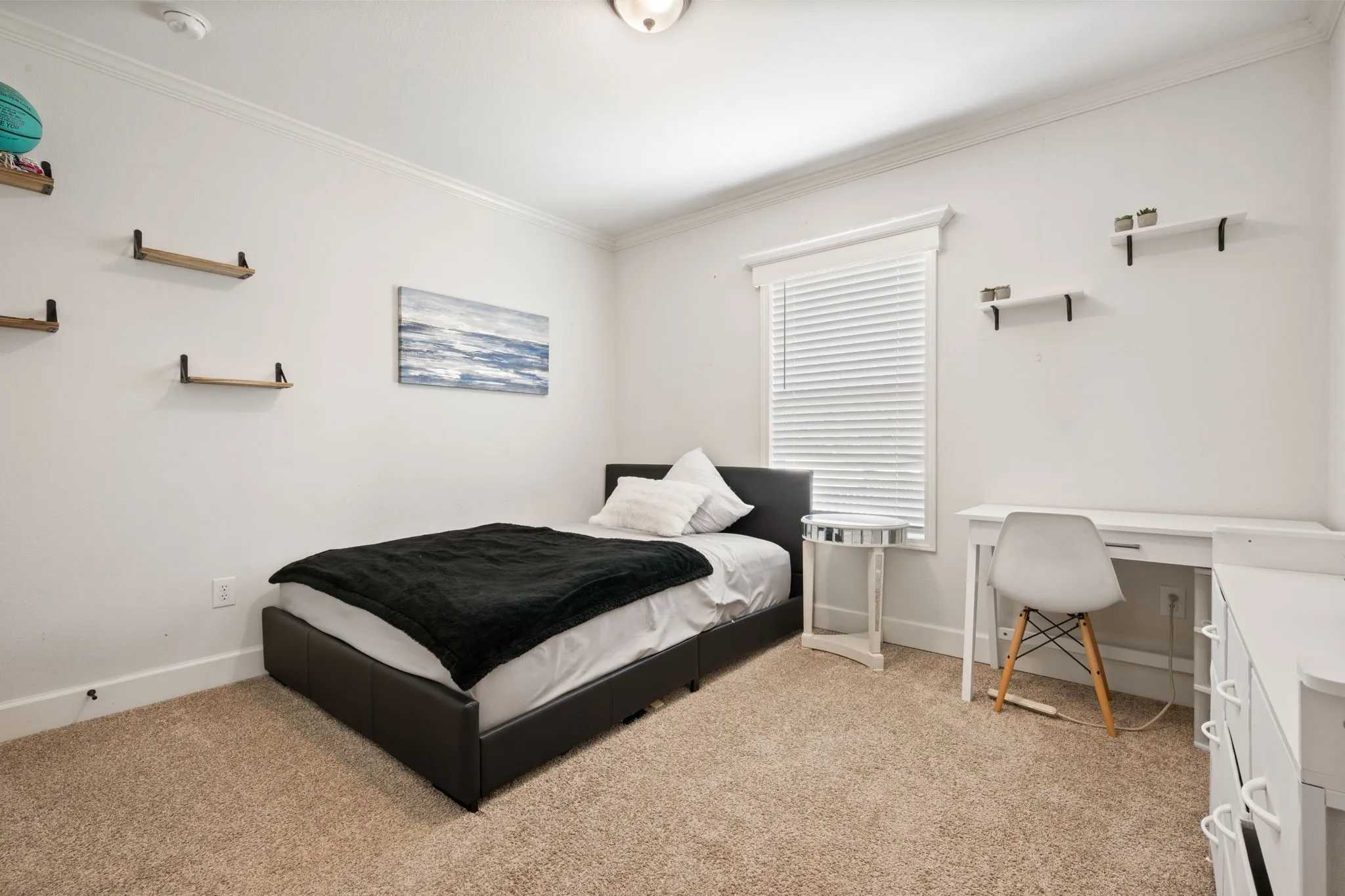 Bedroom with crown molding, an office area, and light colored carpet