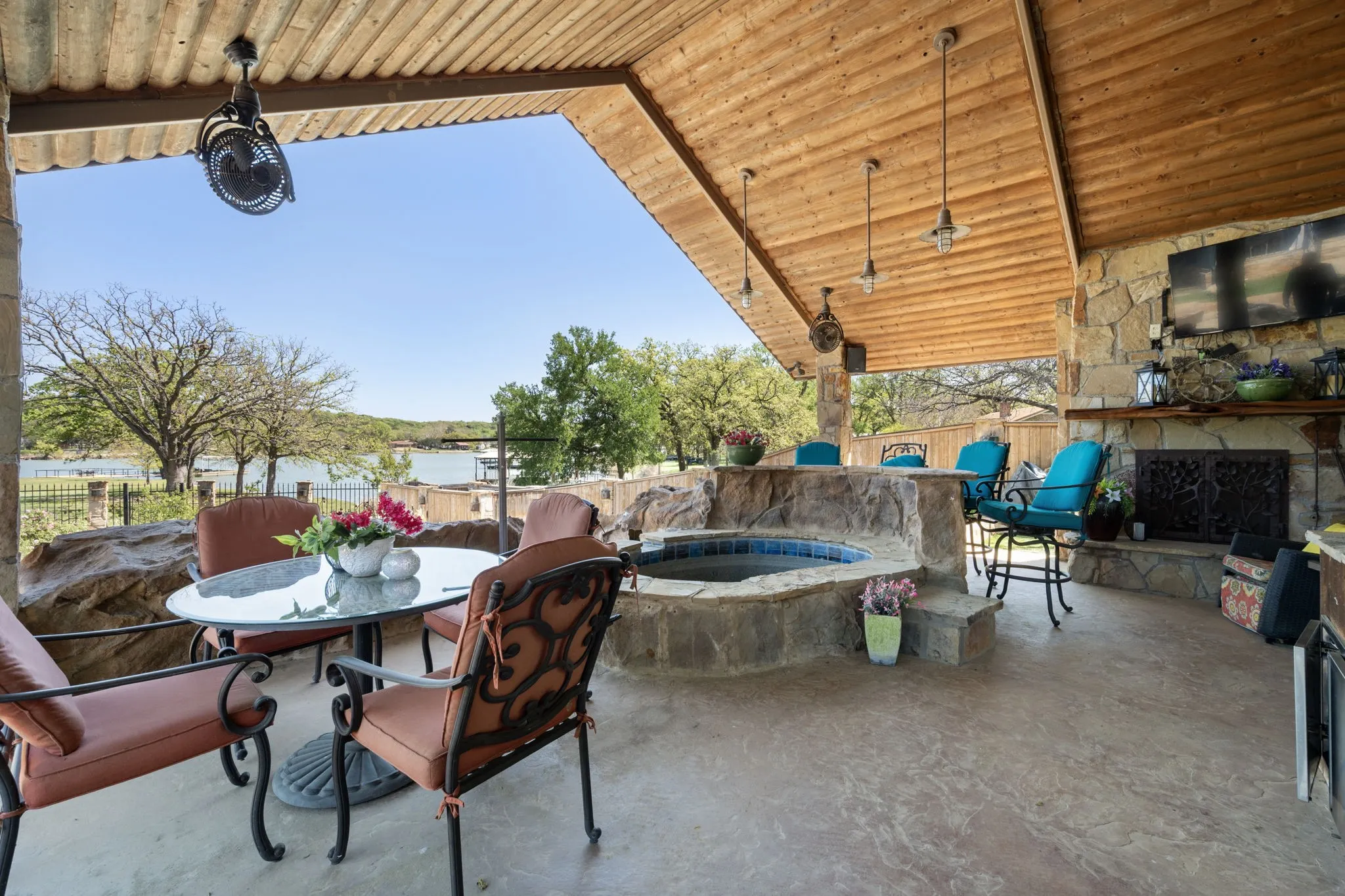 Fenced backyard featuring outdoor dining space, a patio area, and an outdoor stone fireplace