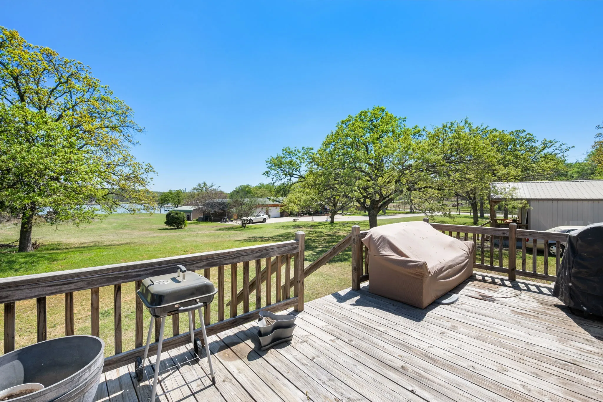 Wooden terrace featuring a yard and area for grilling