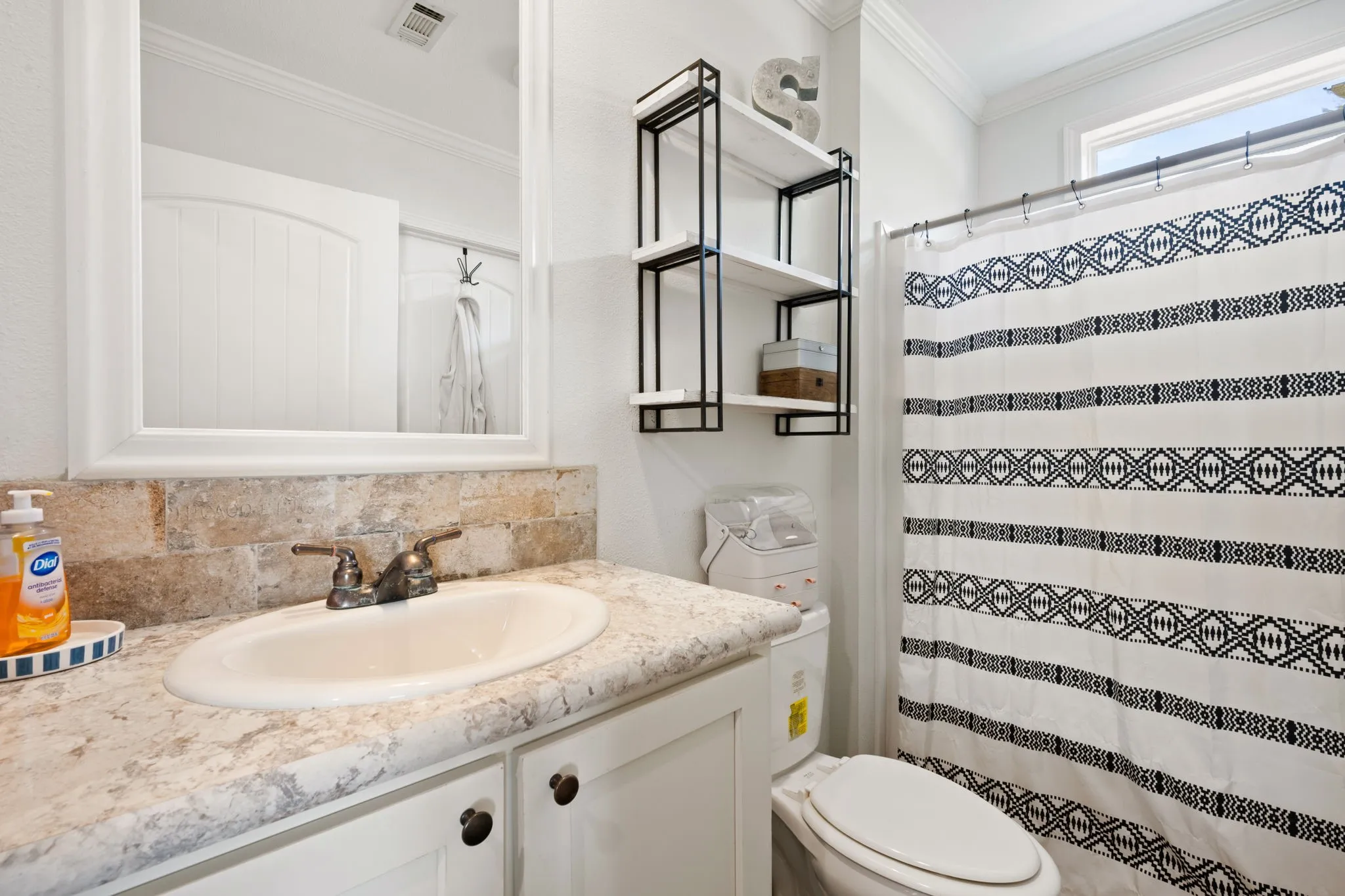 Bathroom with crown molding, vanity, a shower with shower curtain, and decorative backsplash