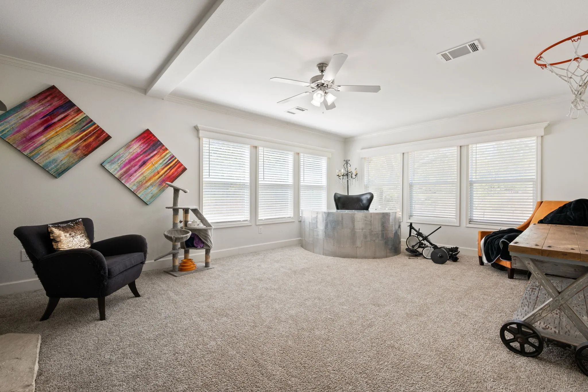 Carpeted office space featuring crown molding, ceiling fan, and beamed ceiling
