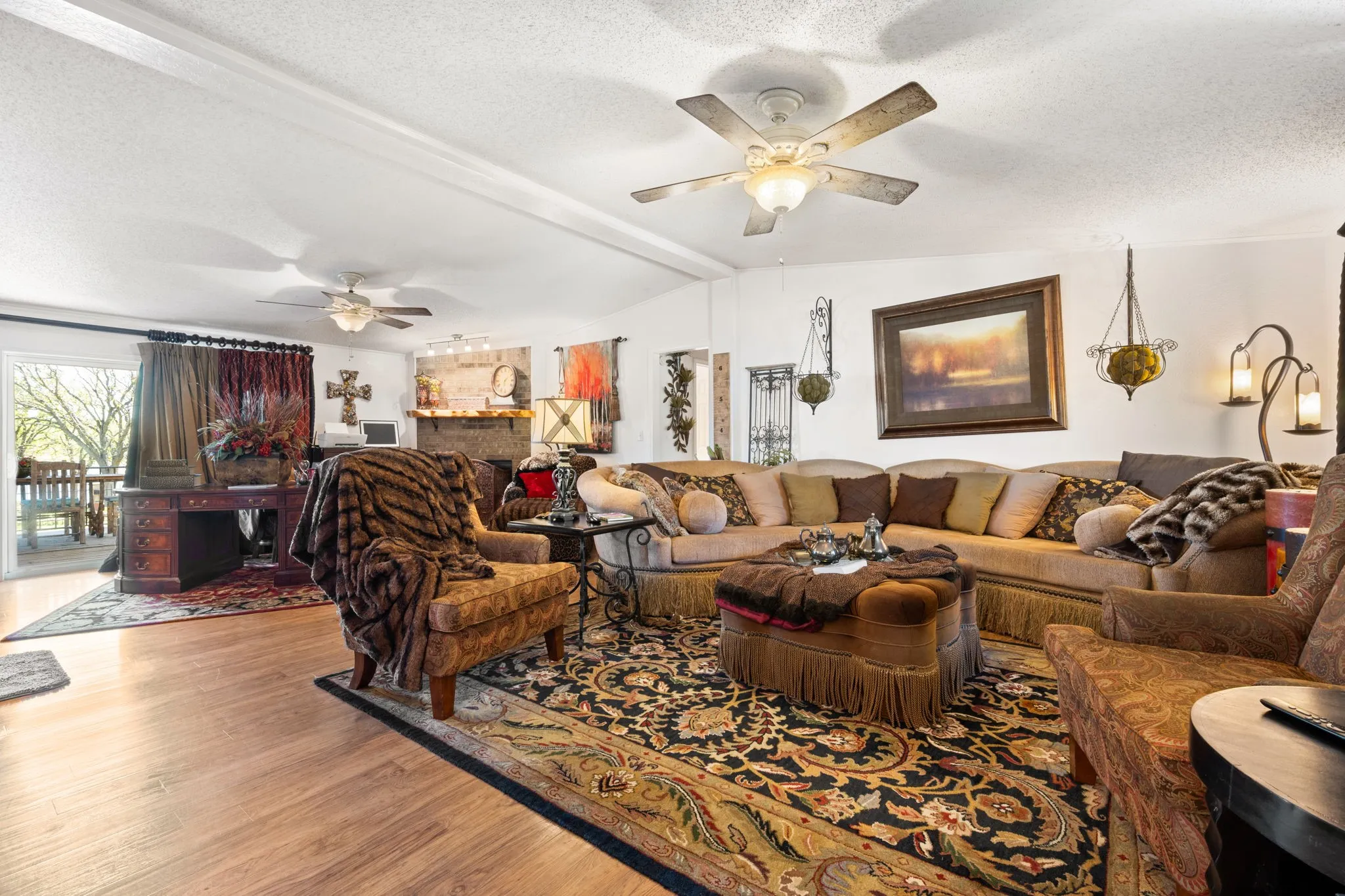 Living area with wood finished floors, ceiling fan, and beamed ceiling