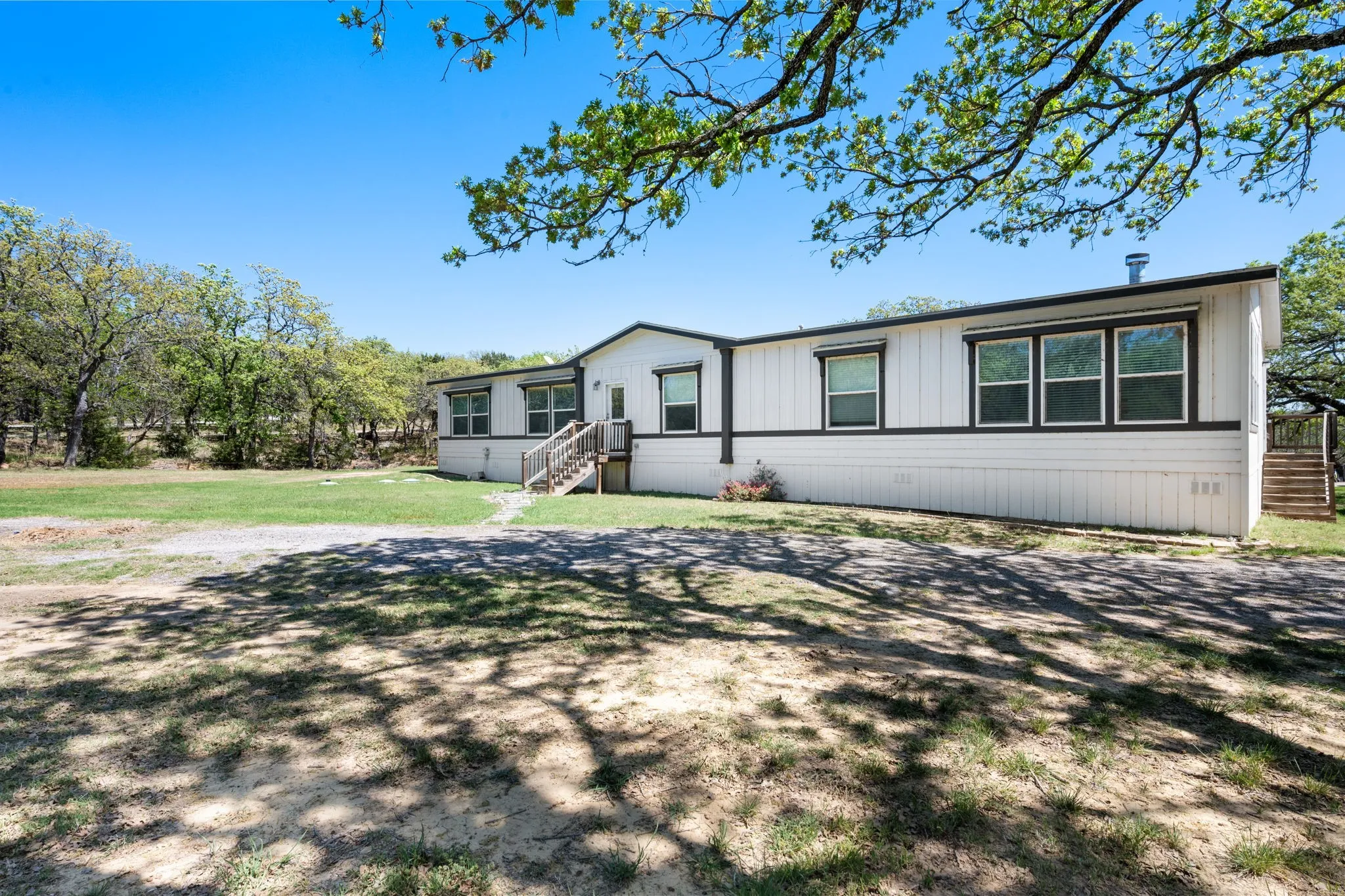 Manufactured / mobile home featuring stairs and a front yard