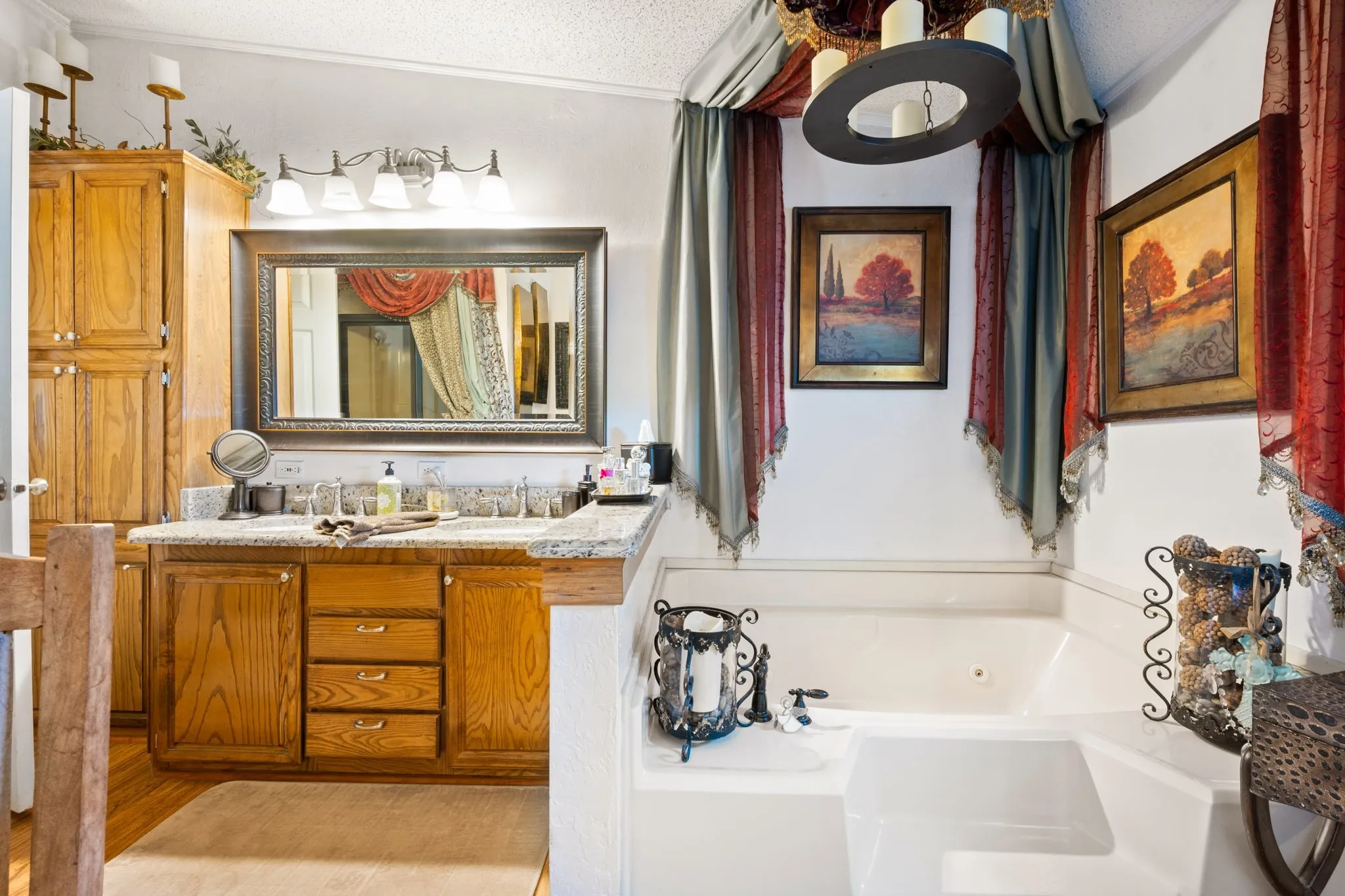Bathroom with double vanity, a textured ceiling, and a jetted tub
