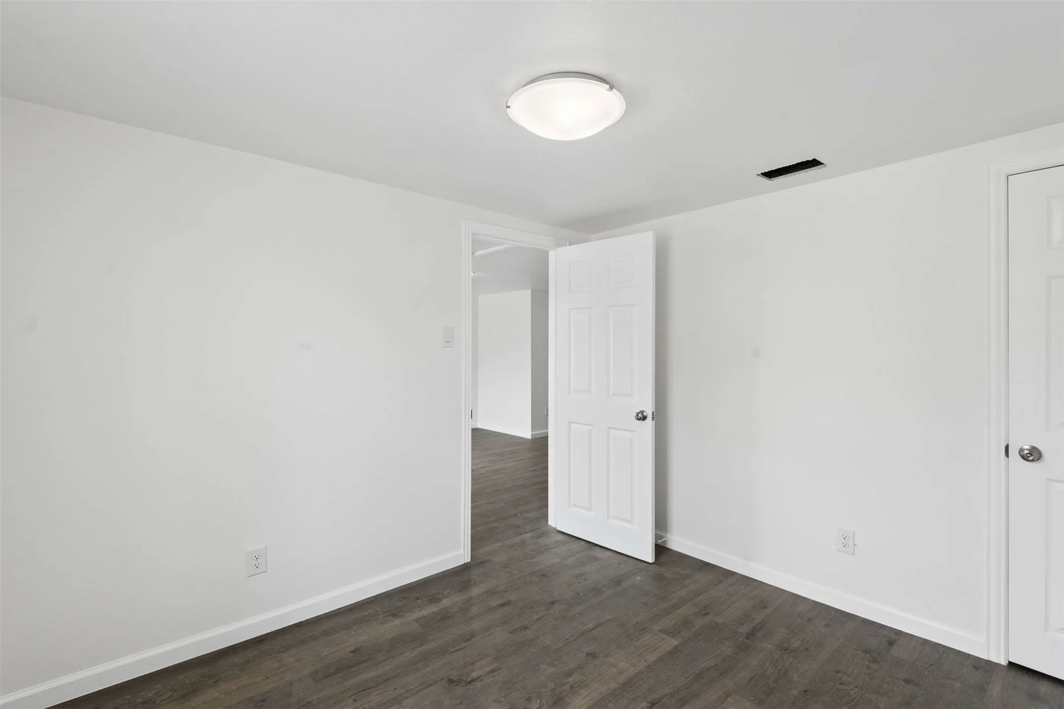 Unfurnished bedroom with dark wood-style floors