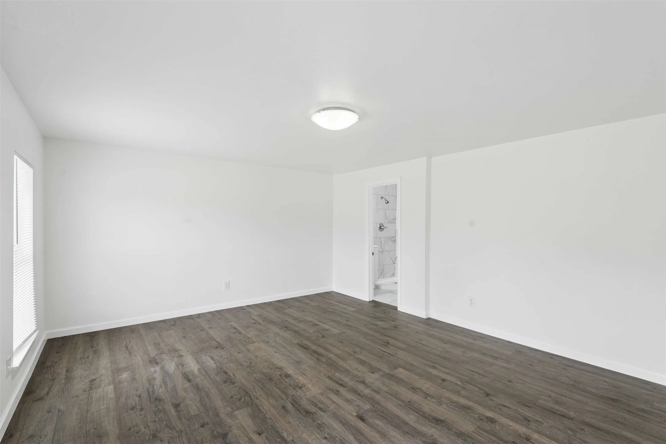 Empty room with dark wood finished floors and baseboards