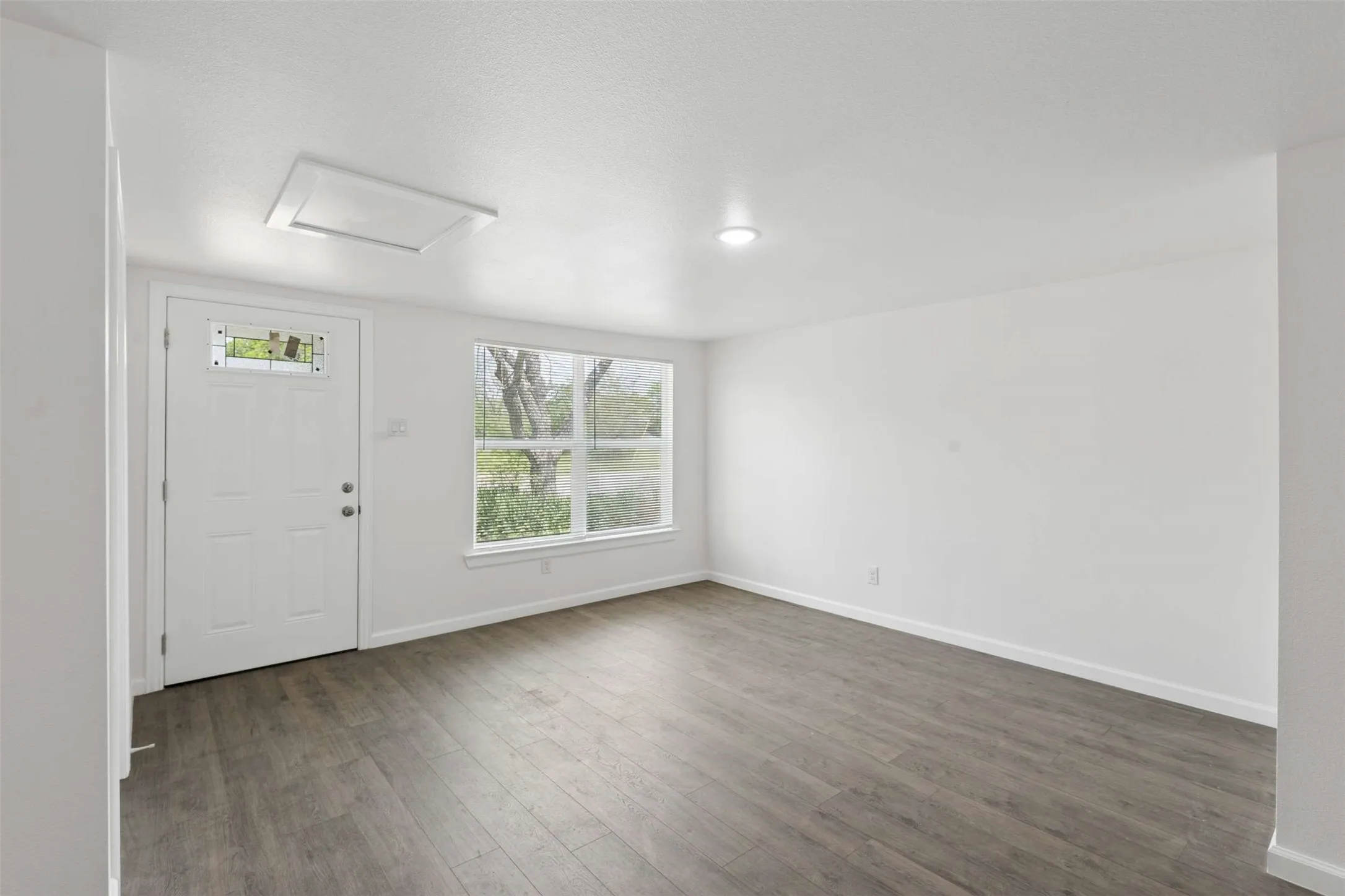 Entrance foyer featuring baseboards and dark wood-style floors