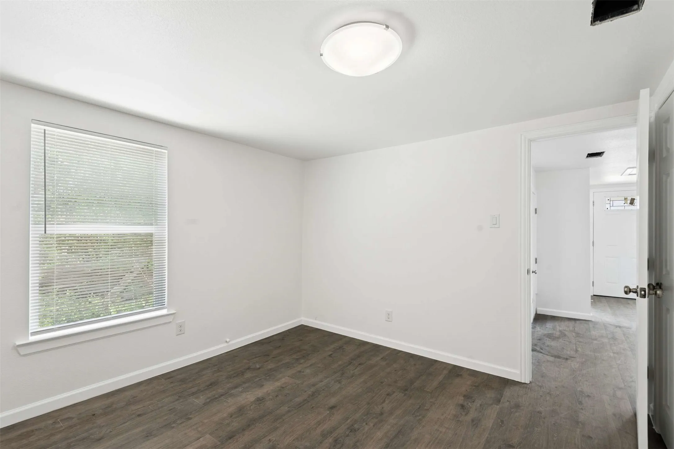 Spare room with dark wood finished floors and baseboards