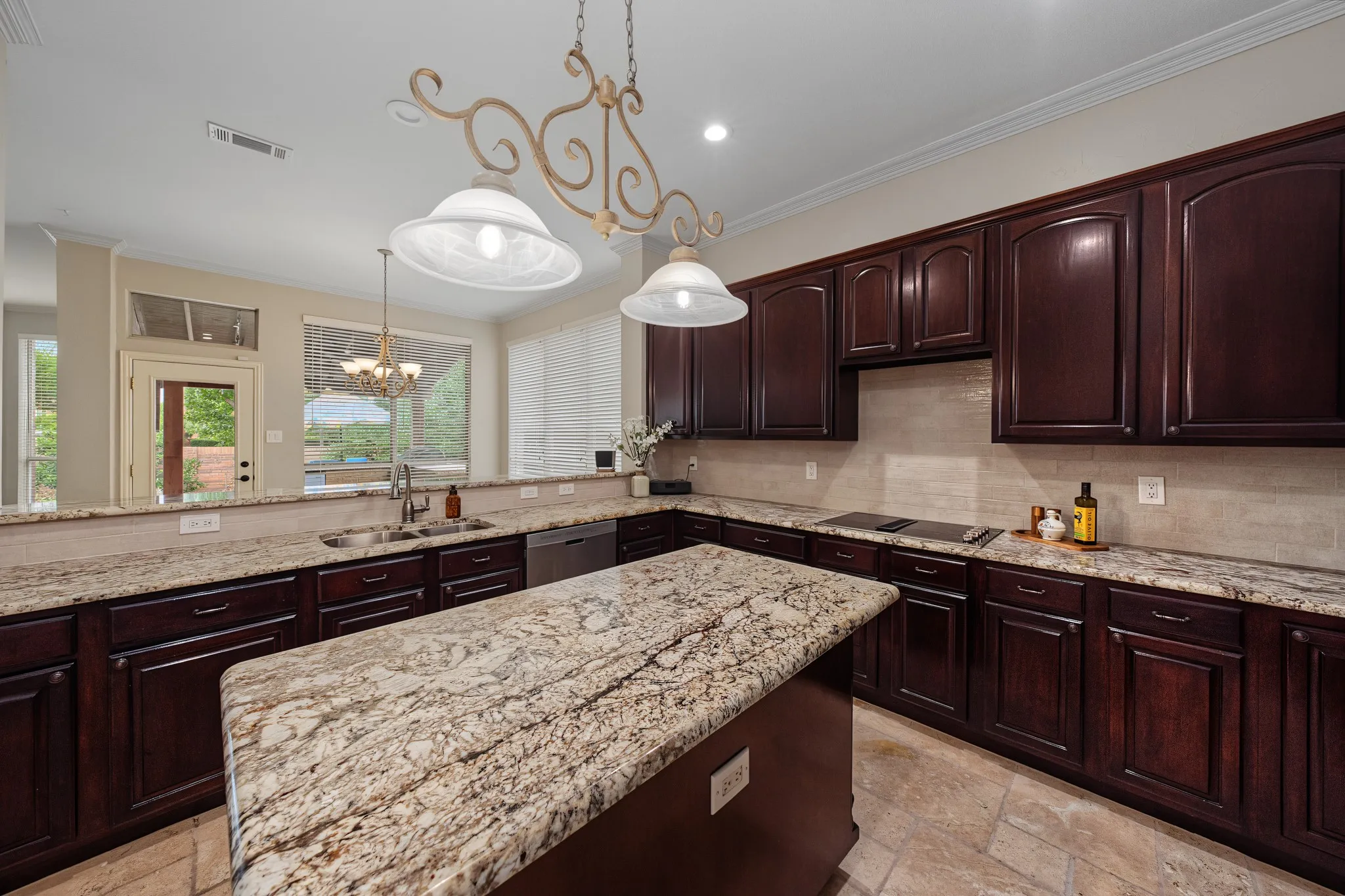 Kitchen featuring a large central island with a stone countertop, dark wood-finish cabinetry, and built-in appliances