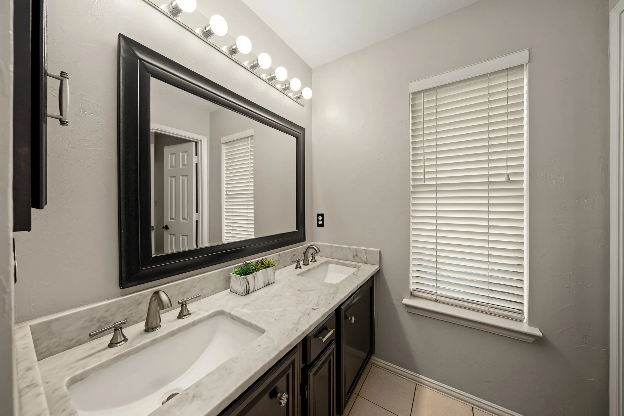 Double vanity with undermount sinks, stone-finish countertop, and brushed nickel fixtures