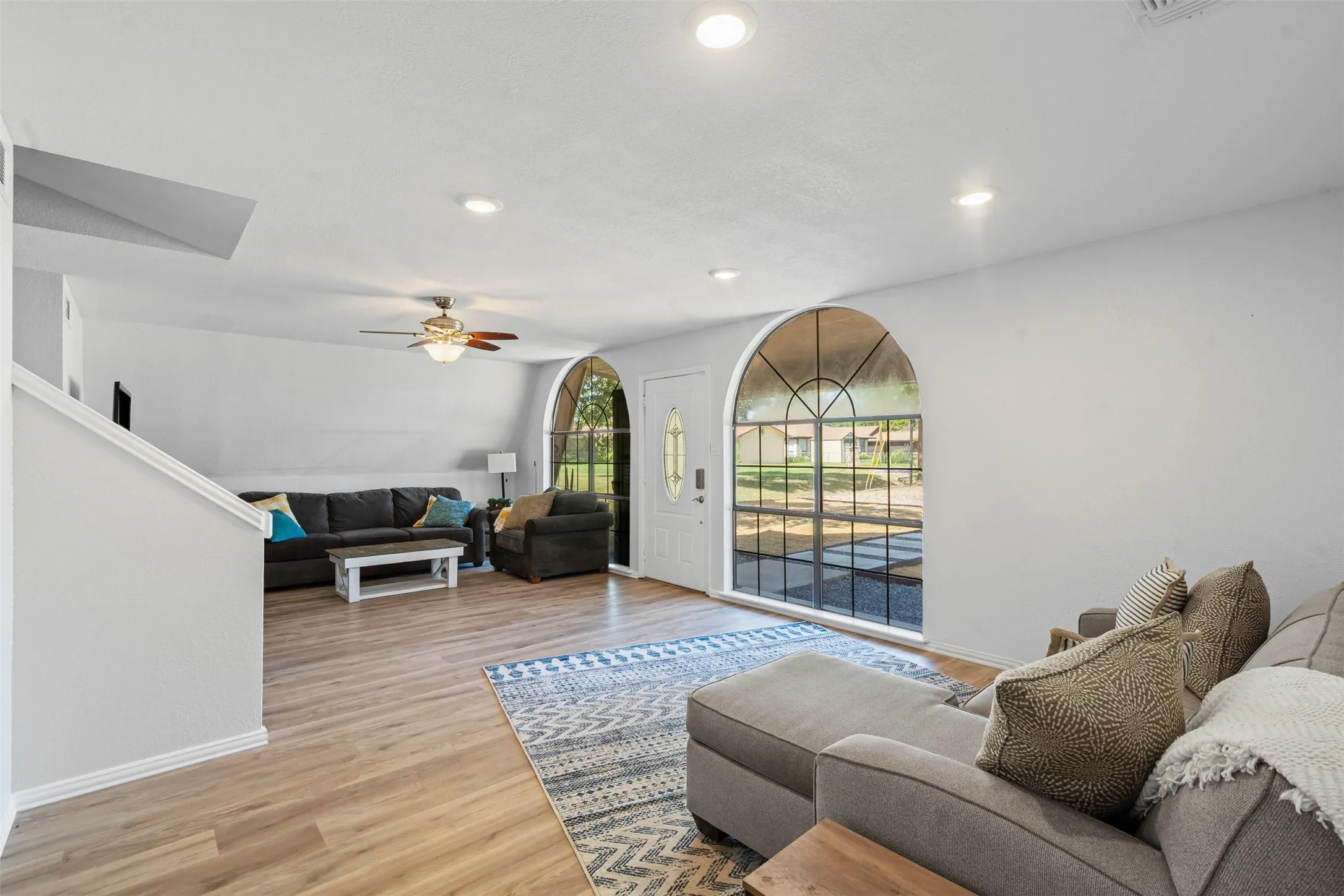 Living room featuring light wood finished floors, ceiling fan, and recessed lighting