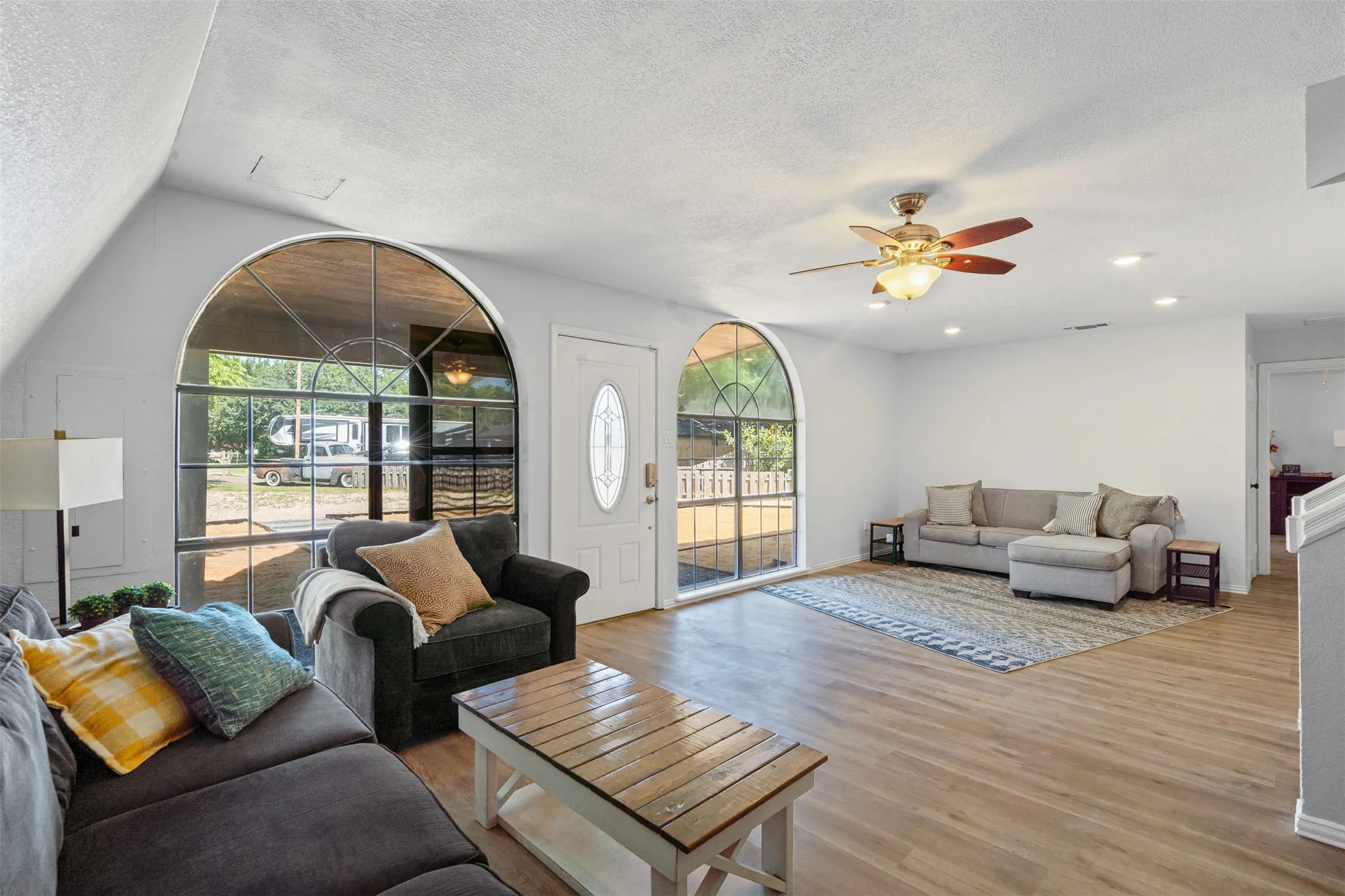 Living area with wood finished floors, ceiling fan, and a textured ceiling