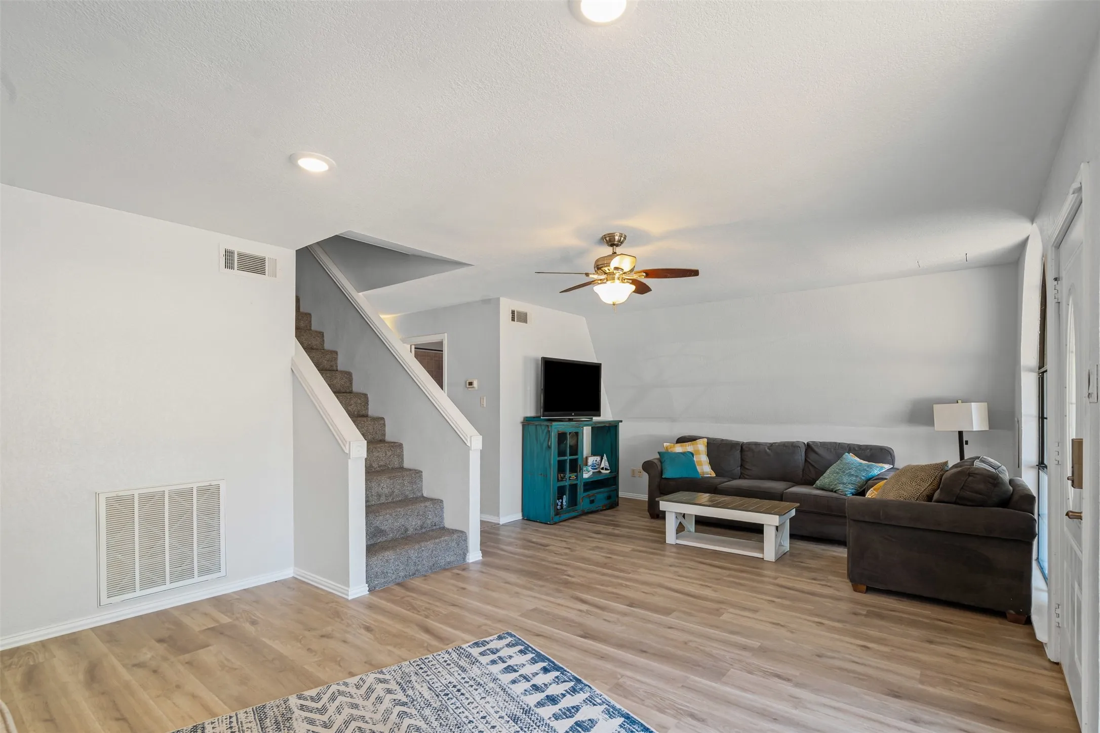 Living area with light wood-style floors, a ceiling fan, and recessed lighting