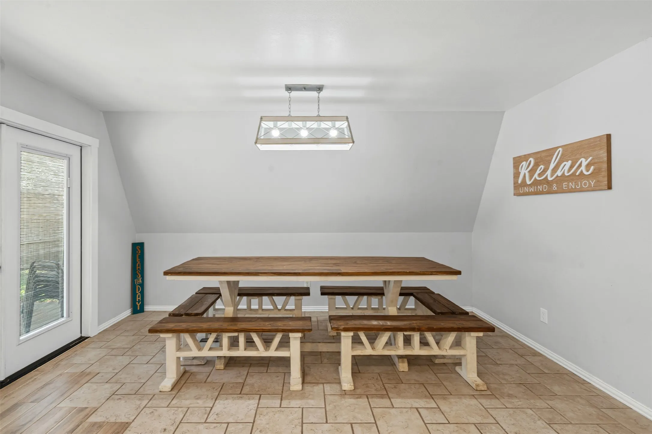 Dining space featuring light stone finish floors and lofted ceiling