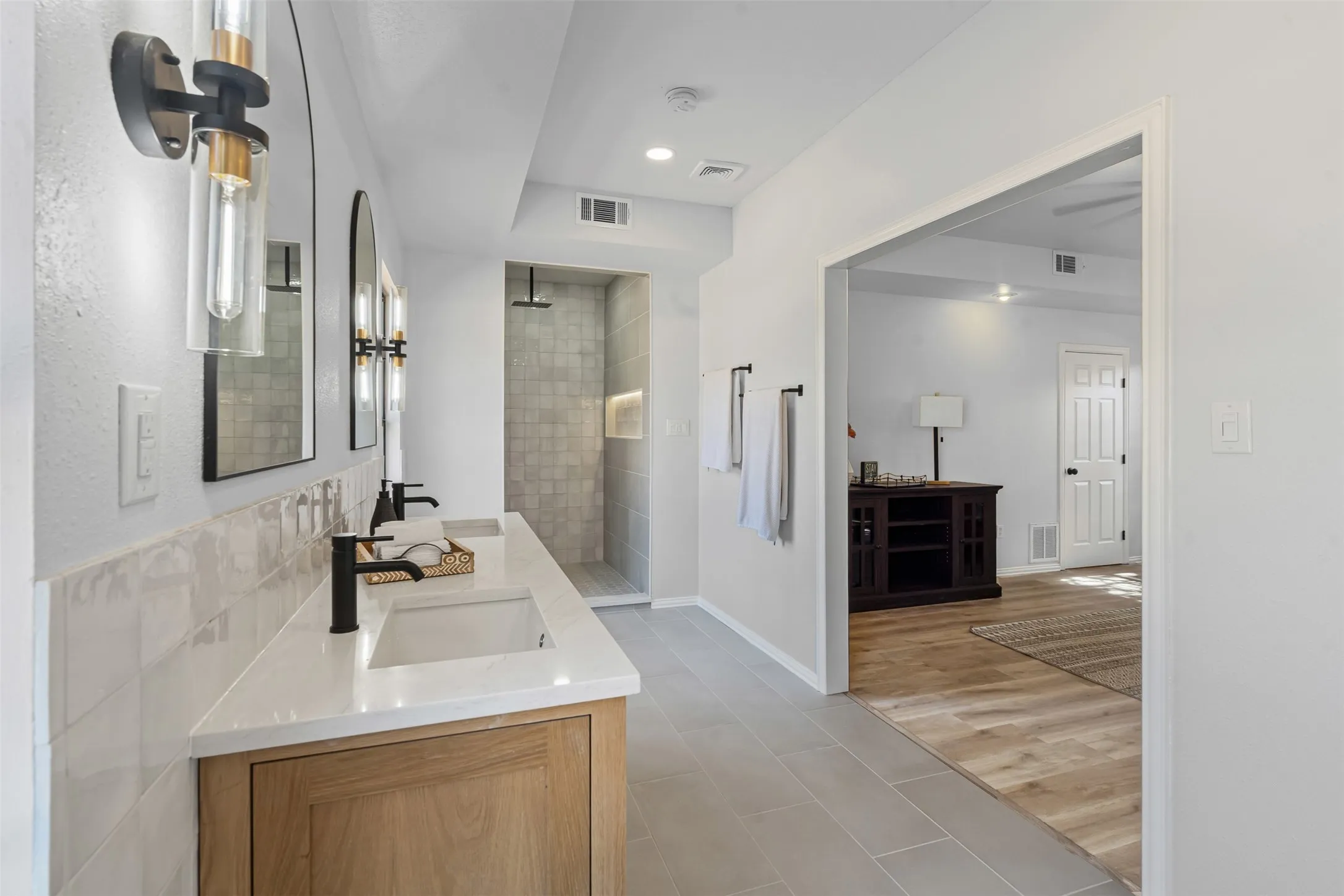 Full bath featuring double vanity, walk in shower, light tile patterned floors, and recessed lighting