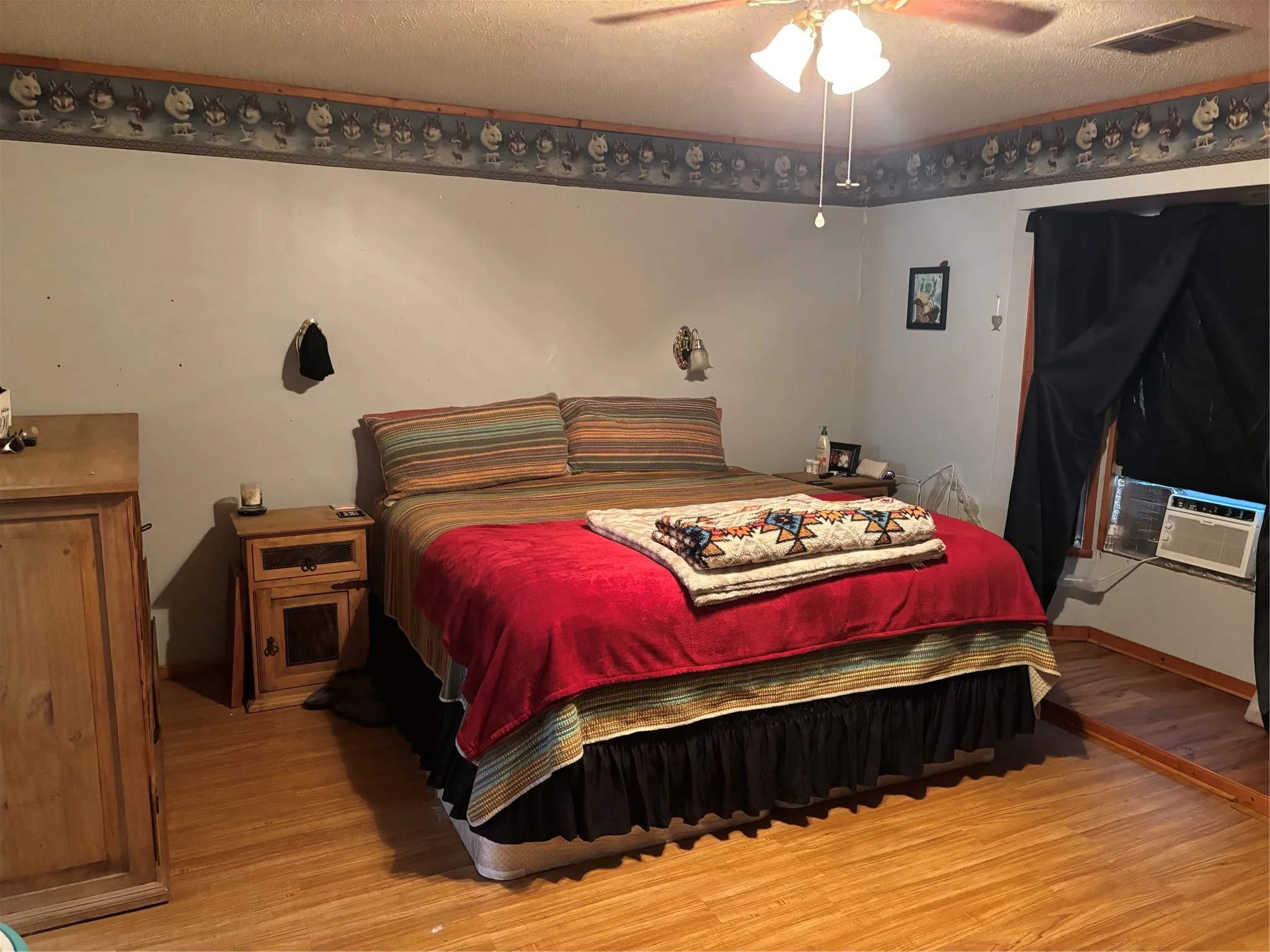Bedroom with light wood-style floors, a textured ceiling, and ceiling fan