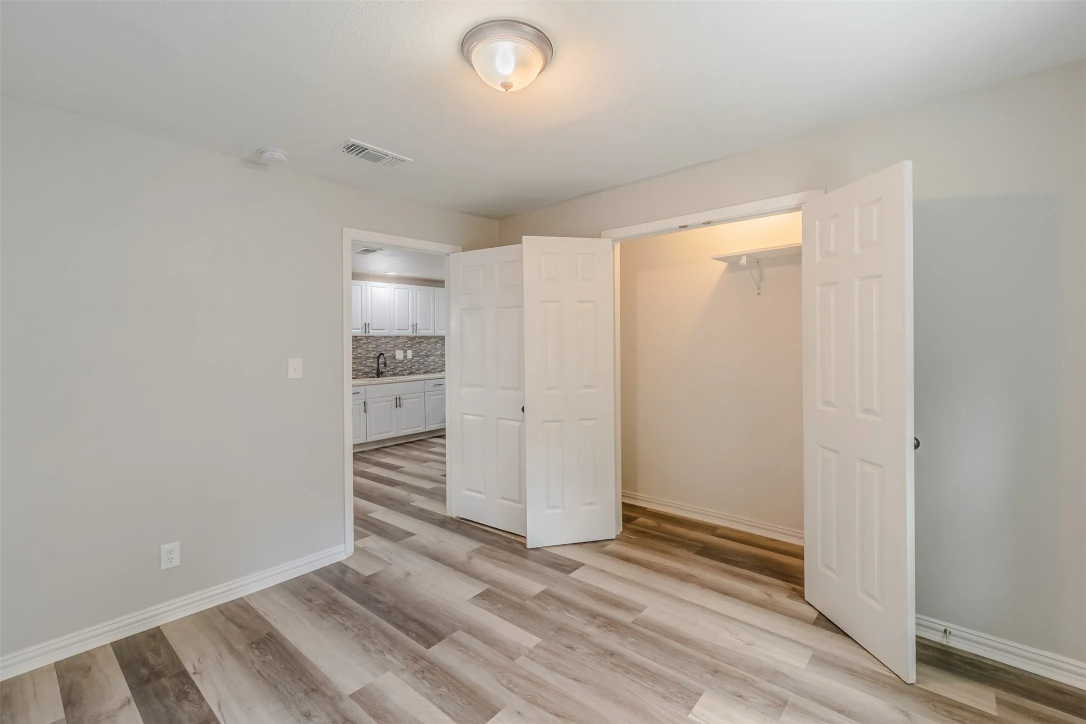 Unfurnished bedroom with light wood-style floors and baseboards
