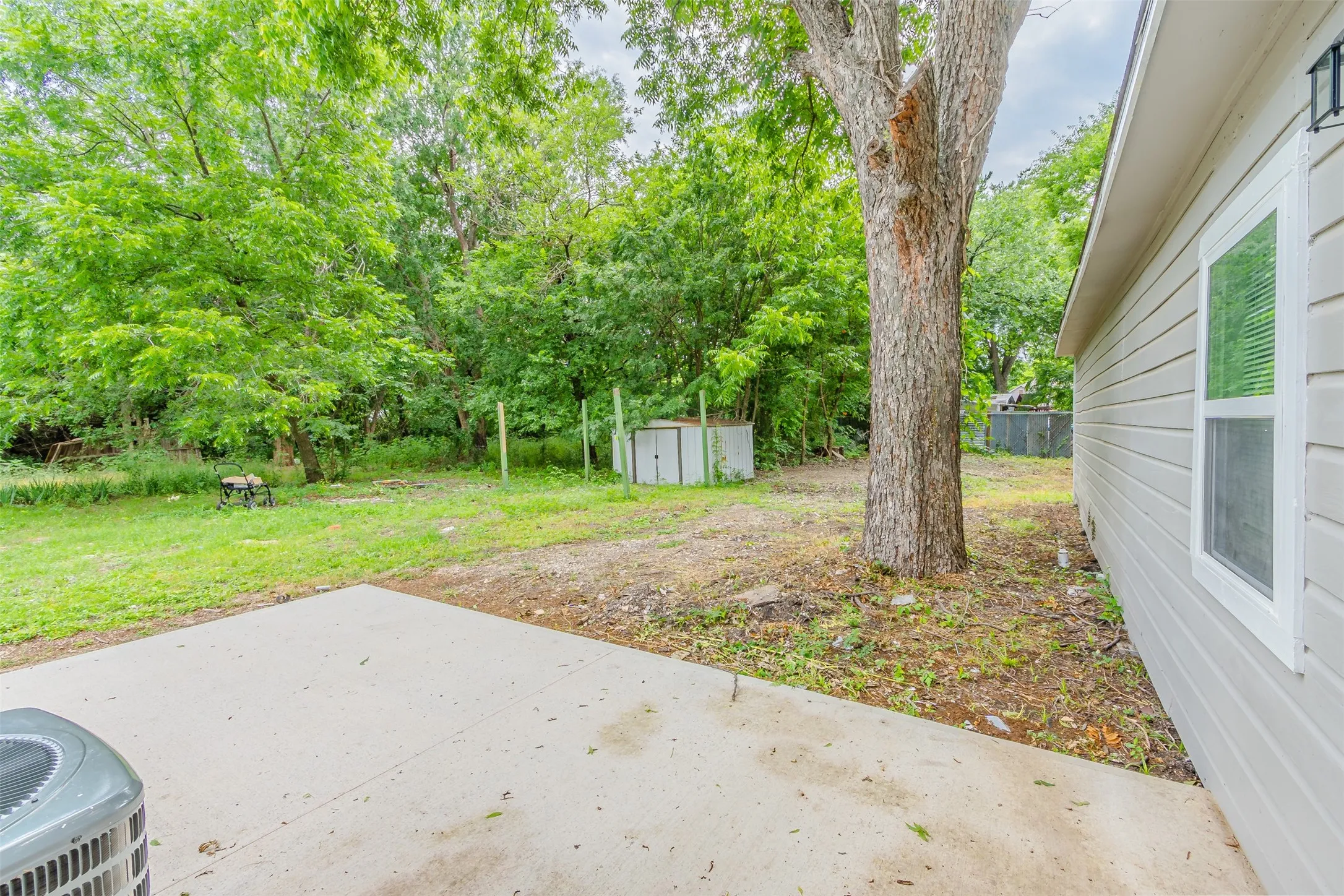 View of yard featuring a storage unit and a patio area