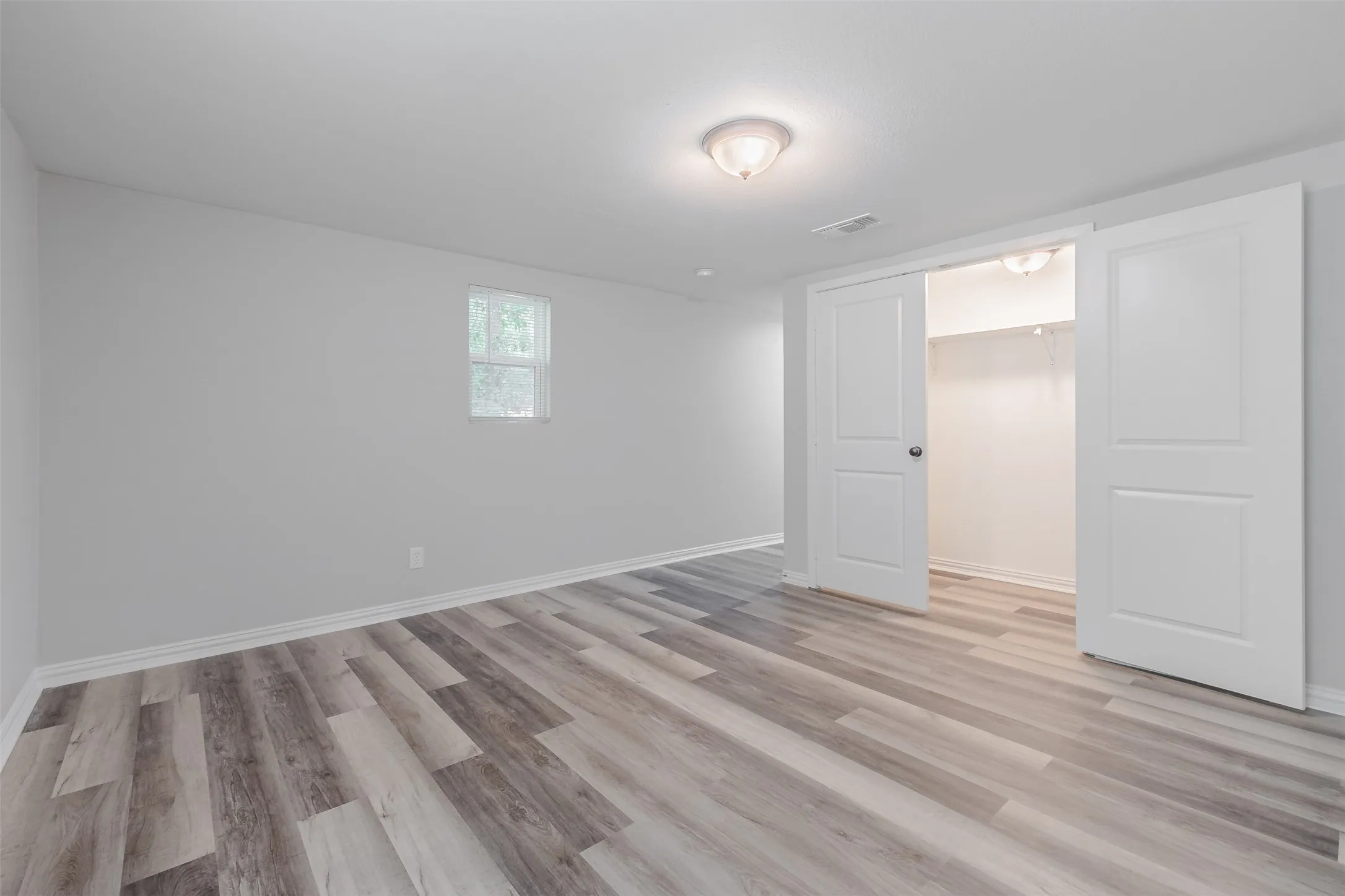 Unfurnished bedroom featuring light wood-type flooring and a spacious​​‌​​​​‌​​‌‌​‌‌​​​‌‌​‌​‌​‌​​​‌​​ closet