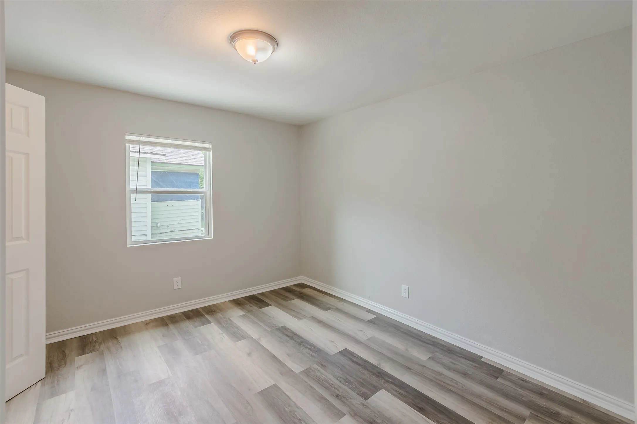 Unfurnished bedroom featuring light wood-style flooring and baseboards