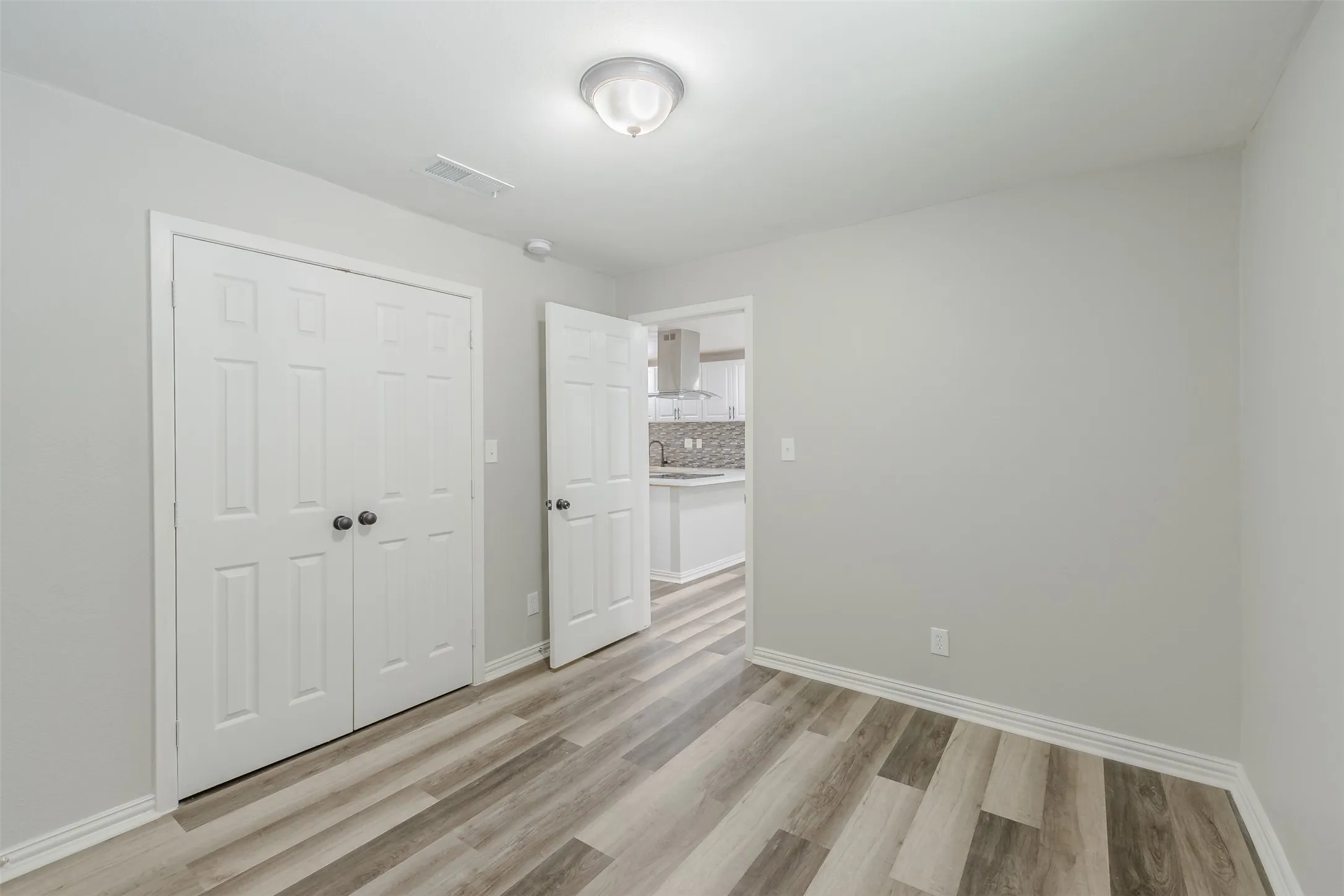 Unfurnished bedroom featuring light wood-type flooring and a closet
