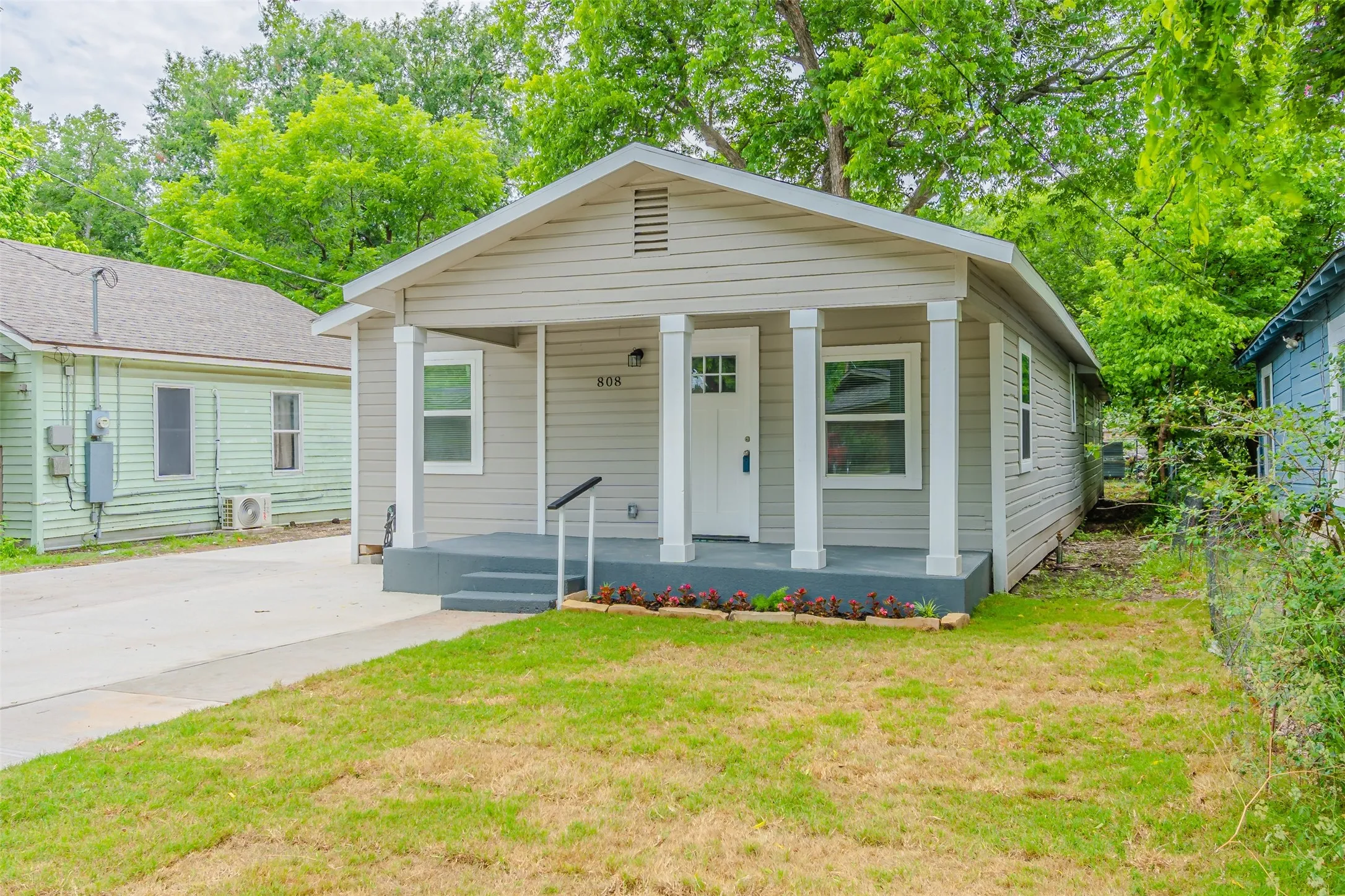 View of front of property featuring covered porch and a front yard