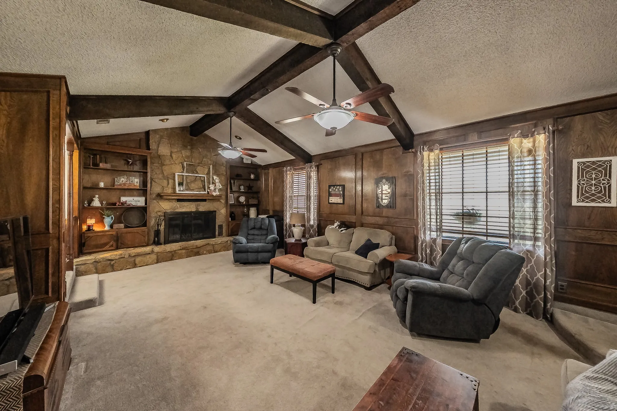 Oversized family room with wood burning fireplace, builtins and expansive brick hearth