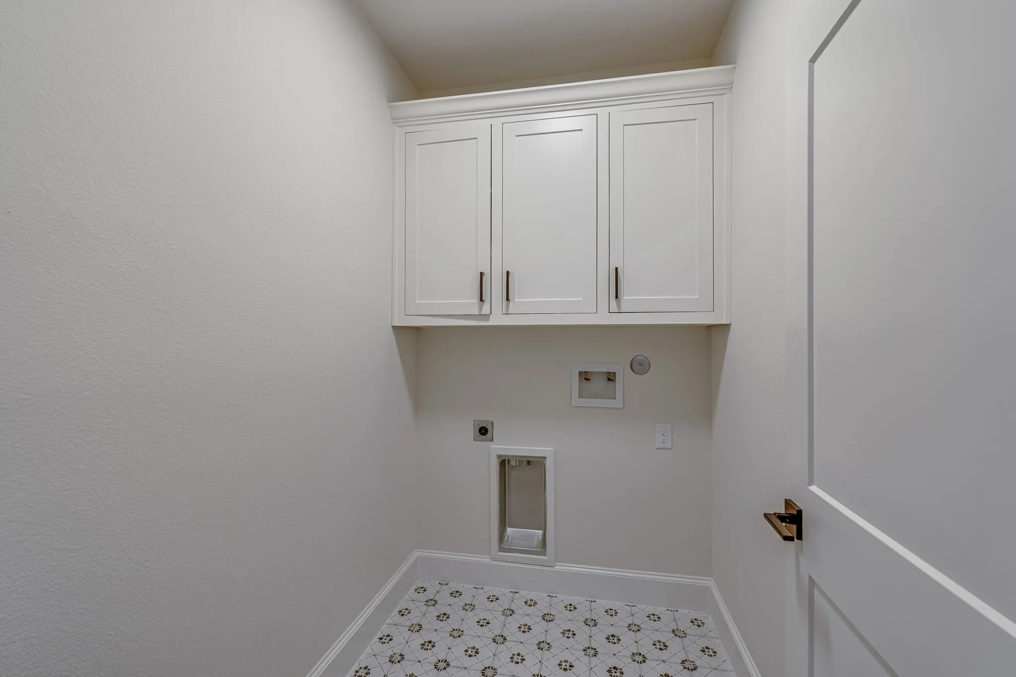 Laundry room with cabinet space, hookup for an electric dryer, hookup for a washing machine, and light floors