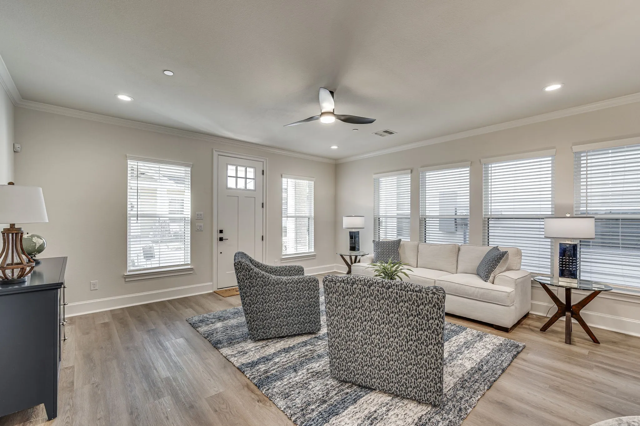 Living room with a ceiling fan, light wood-type flooring, crown molding, and recessed lighting