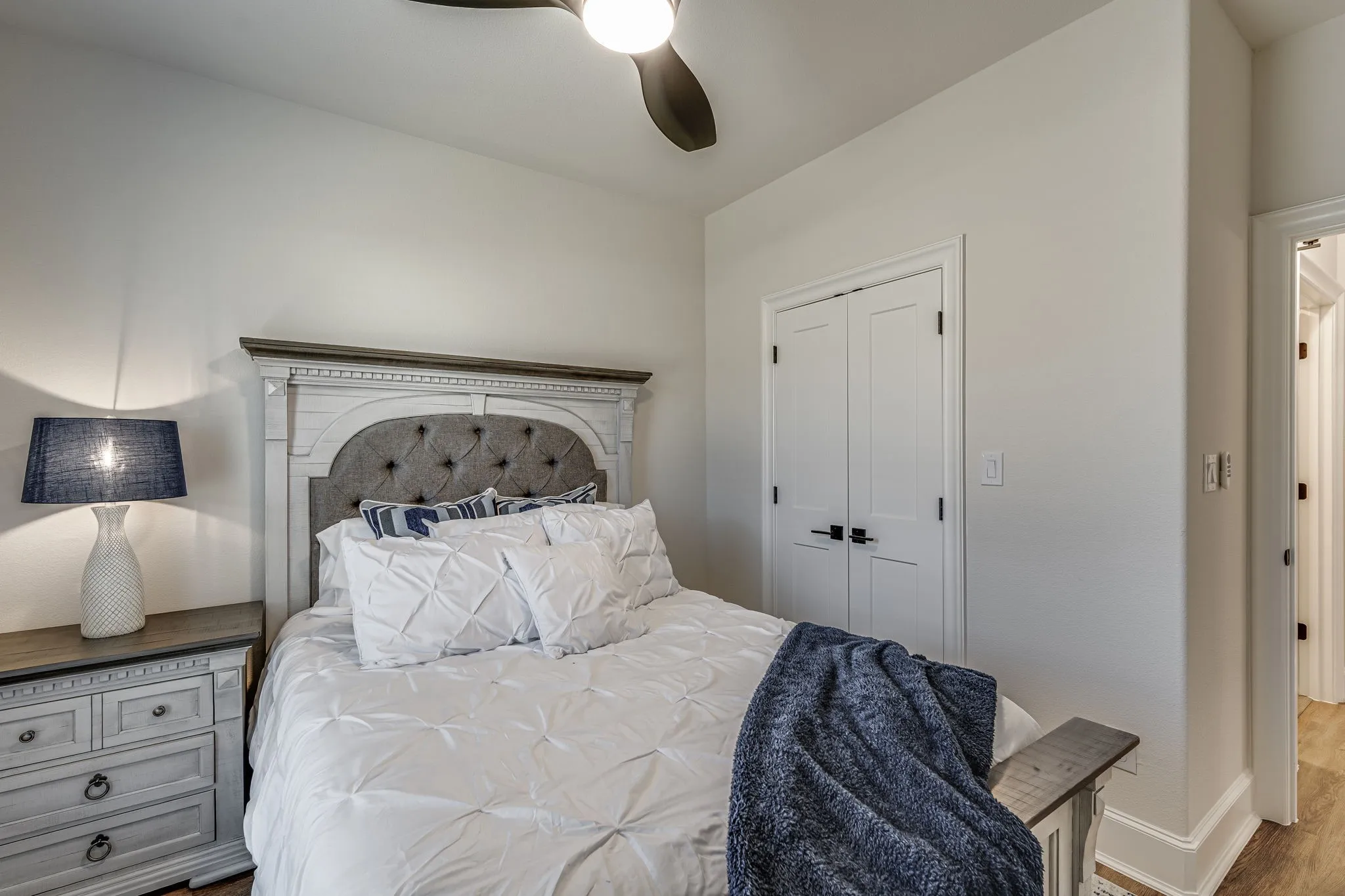 Bedroom with ceiling fan, wood finished floors, and a closet