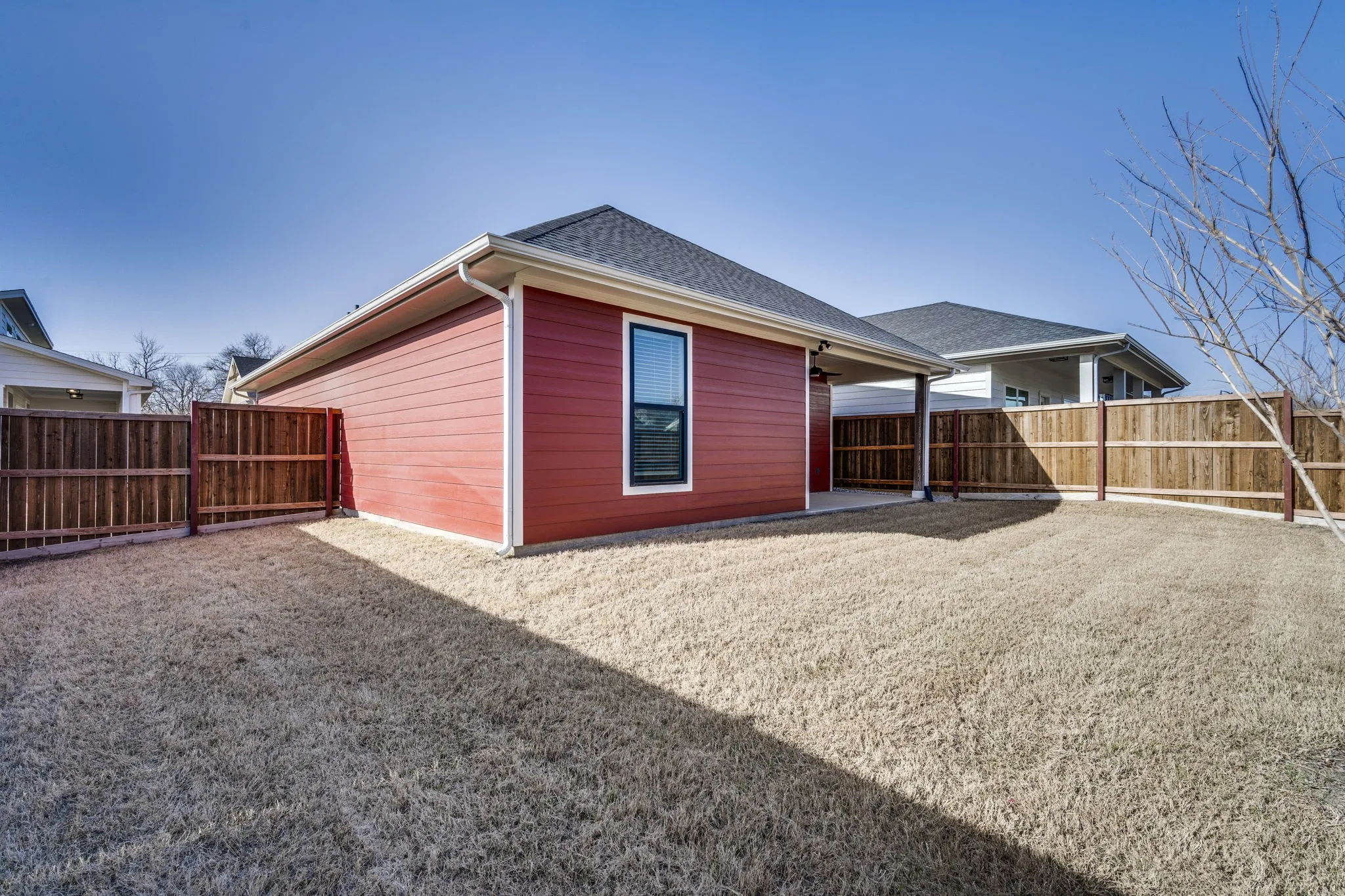 Rear view of house with a patio area, a fenced backyard, and roof with shingles