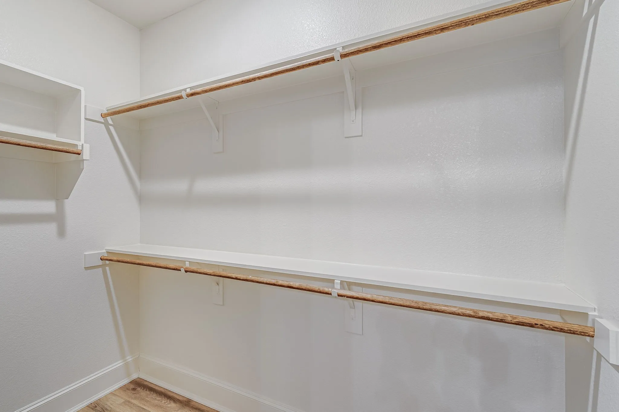 Walk in closet with light wood-type flooring