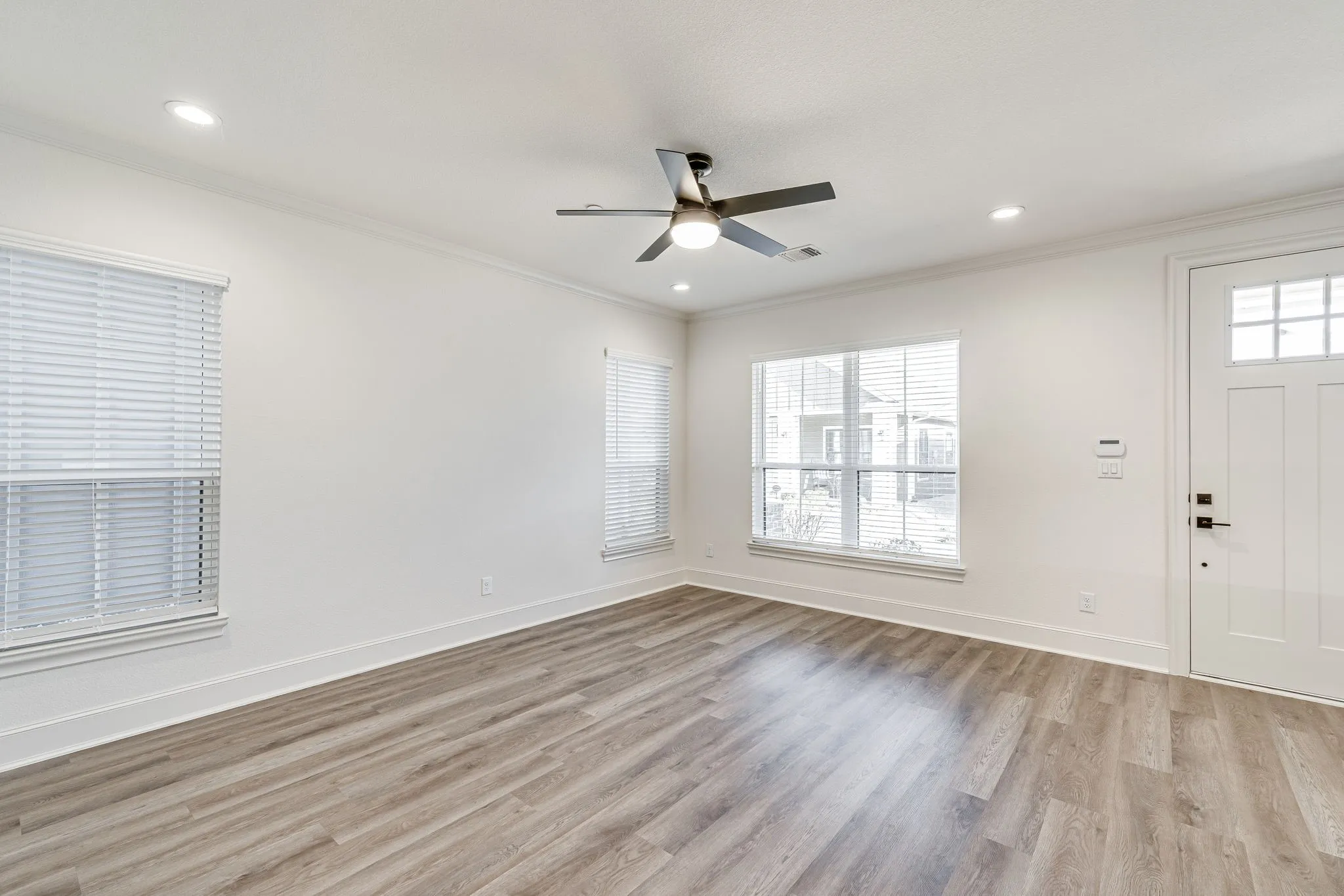Foyer entrance featuring light wood-style flooring, a ceiling fan, ornamental molding, healthy amount of natural light, and recessed lighting
