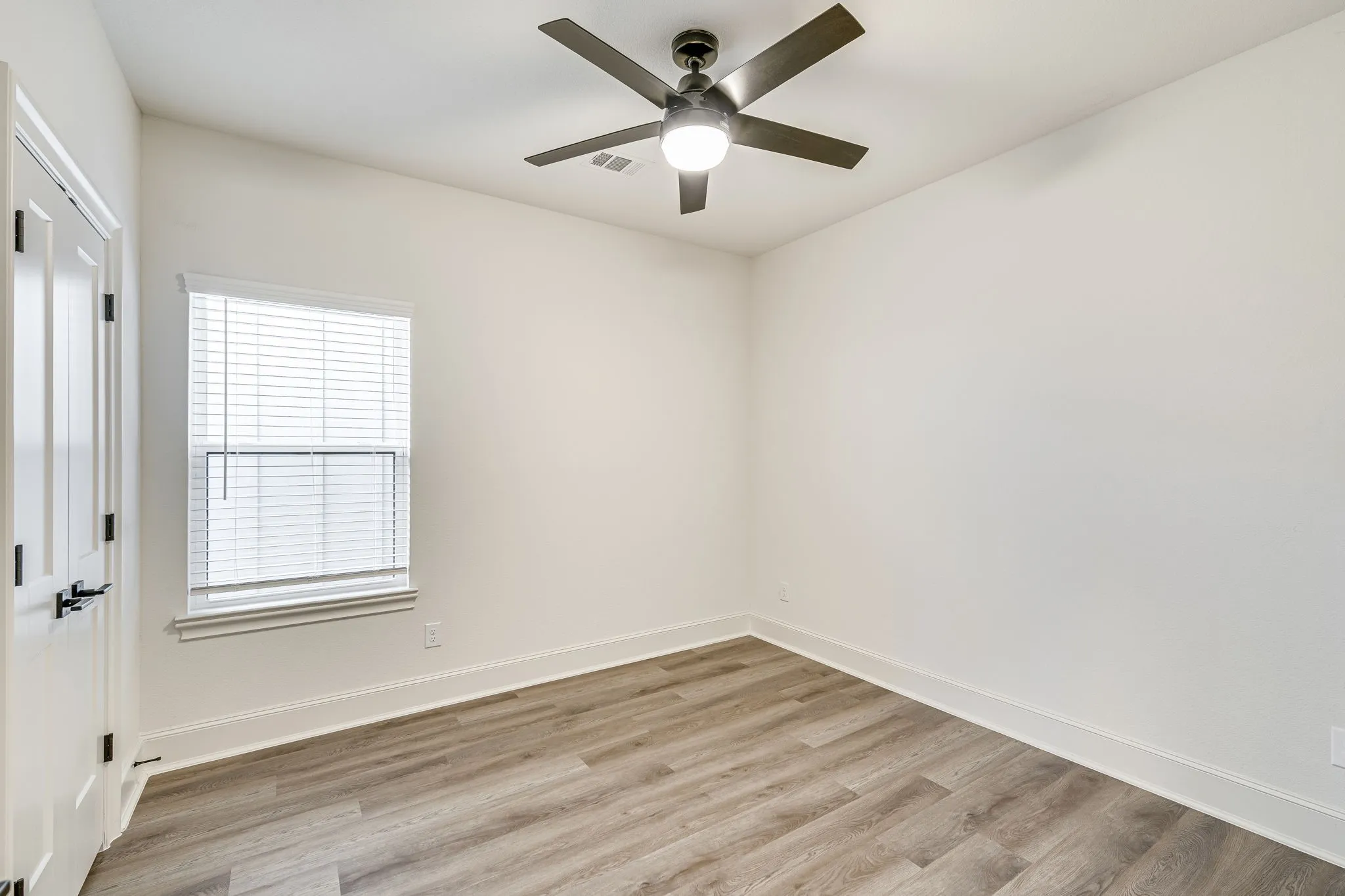 Unfurnished room with light wood finished floors and a ceiling fan