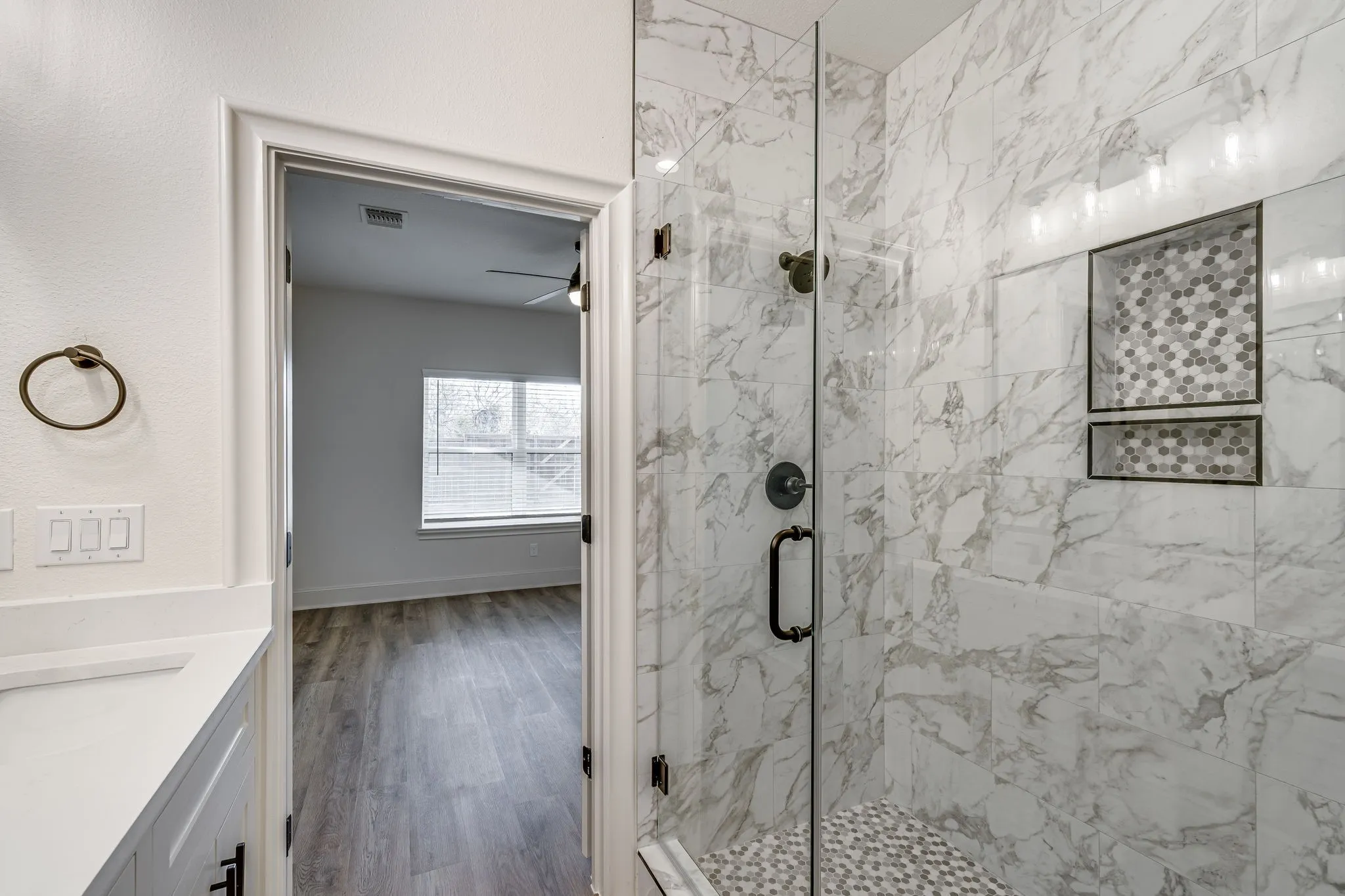 Bathroom featuring dark wood finished floors, a marble finish shower, vanity, and ceiling fan