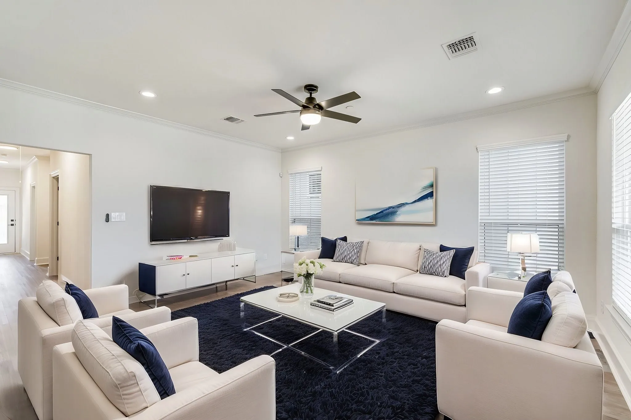 Living area featuring crown molding, ceiling fan, wood finished floors, recessed lighting, and healthy amount of natural light