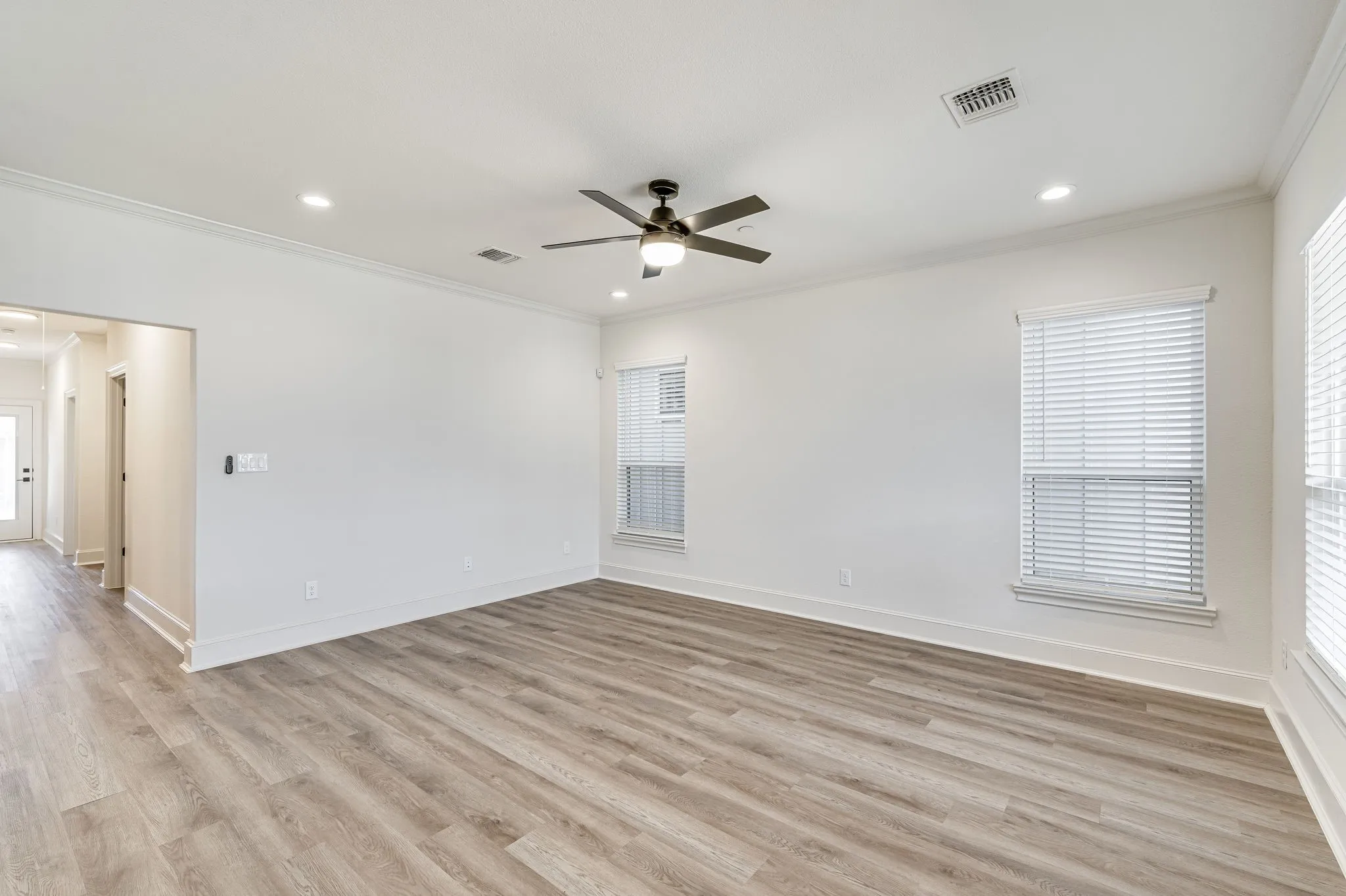 Unfurnished room with ornamental molding, light wood-style floors, a ceiling fan, and recessed lighting