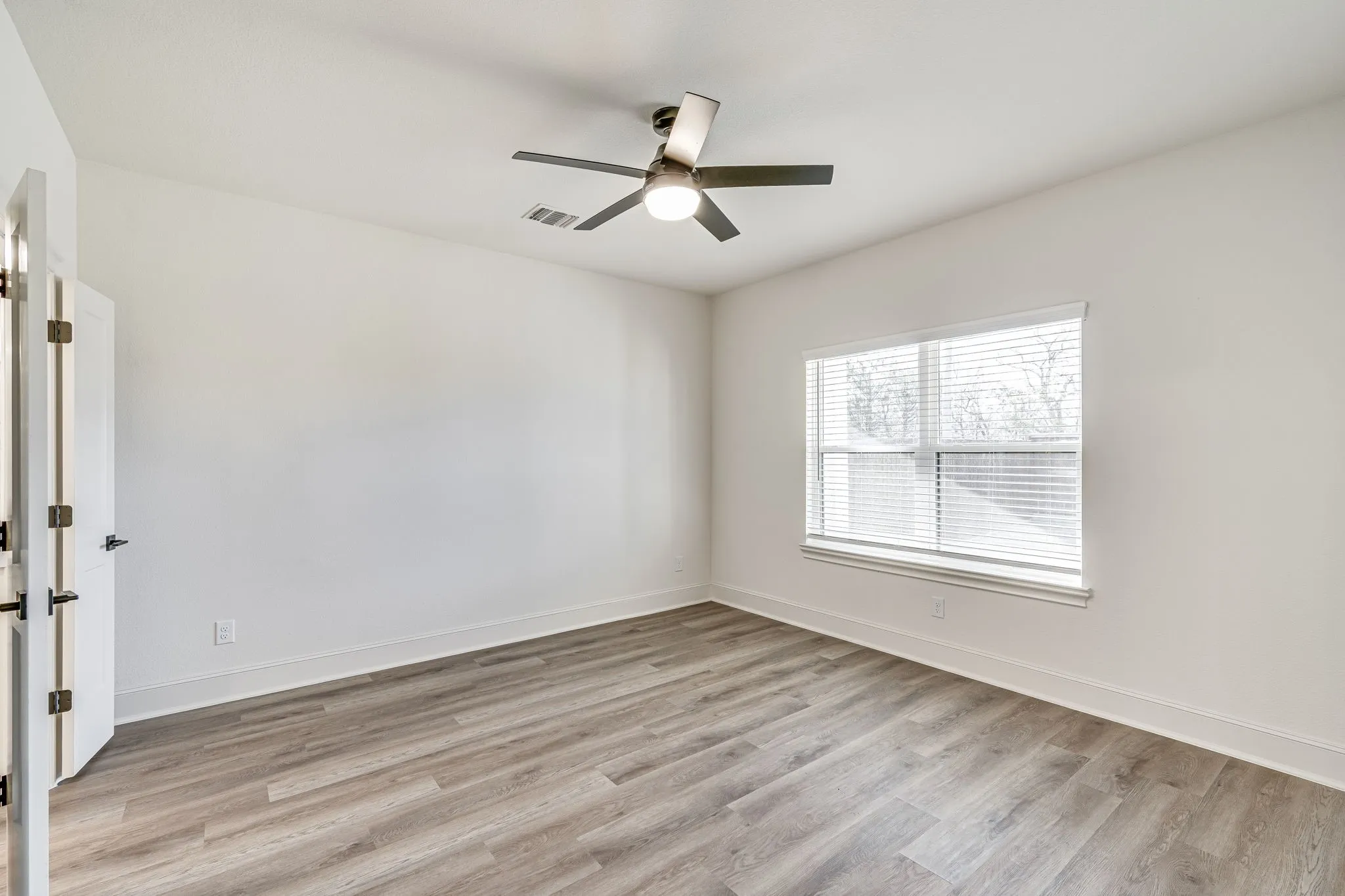 Spare room with light wood-type flooring and ceiling fan