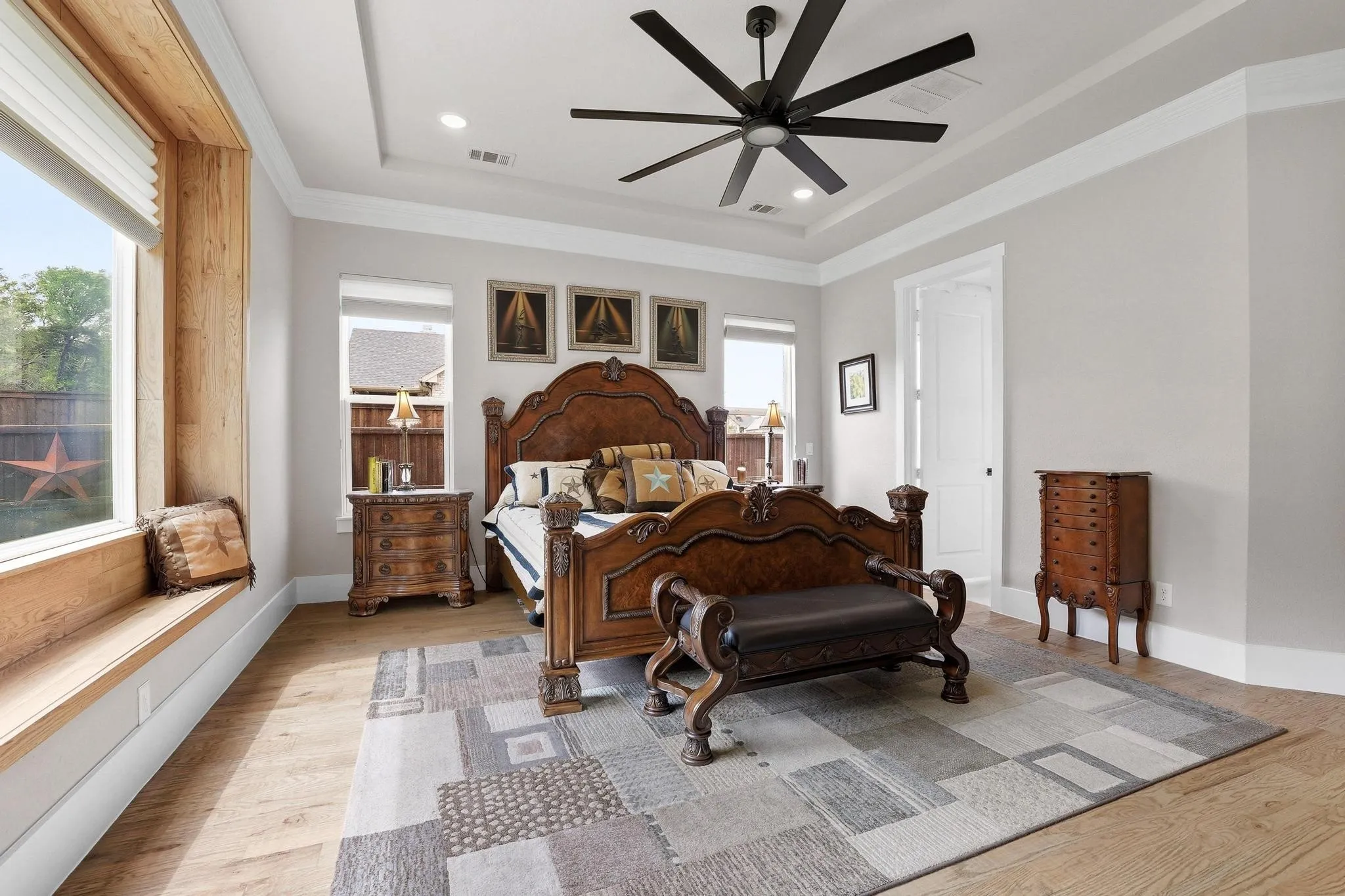 Bedroom with light wood finished floors, ceiling fan, a tray ceiling, recessed lighting, and ornamental molding