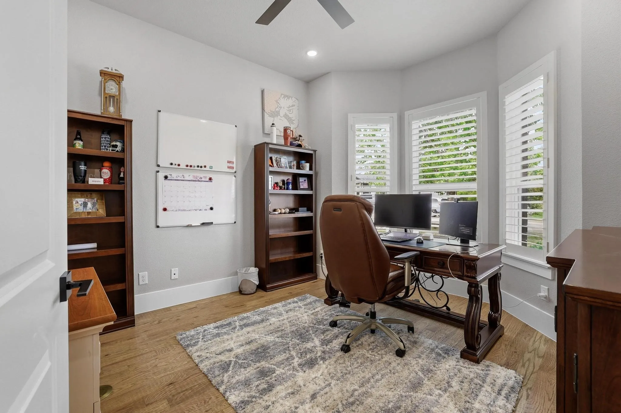 Home office with light wood finished floors, ceiling fan, and recessed lighting