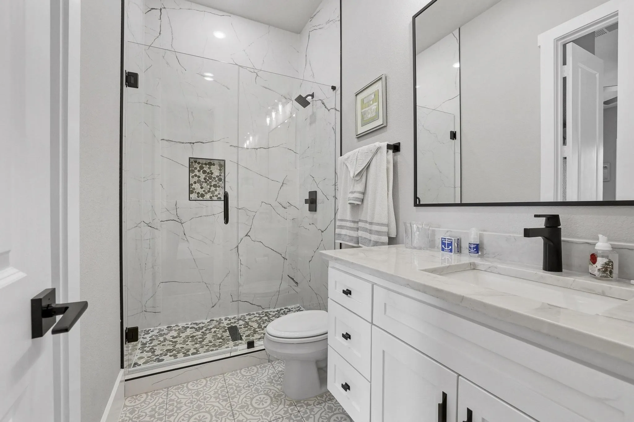 Bathroom with vanity and a marble finish shower