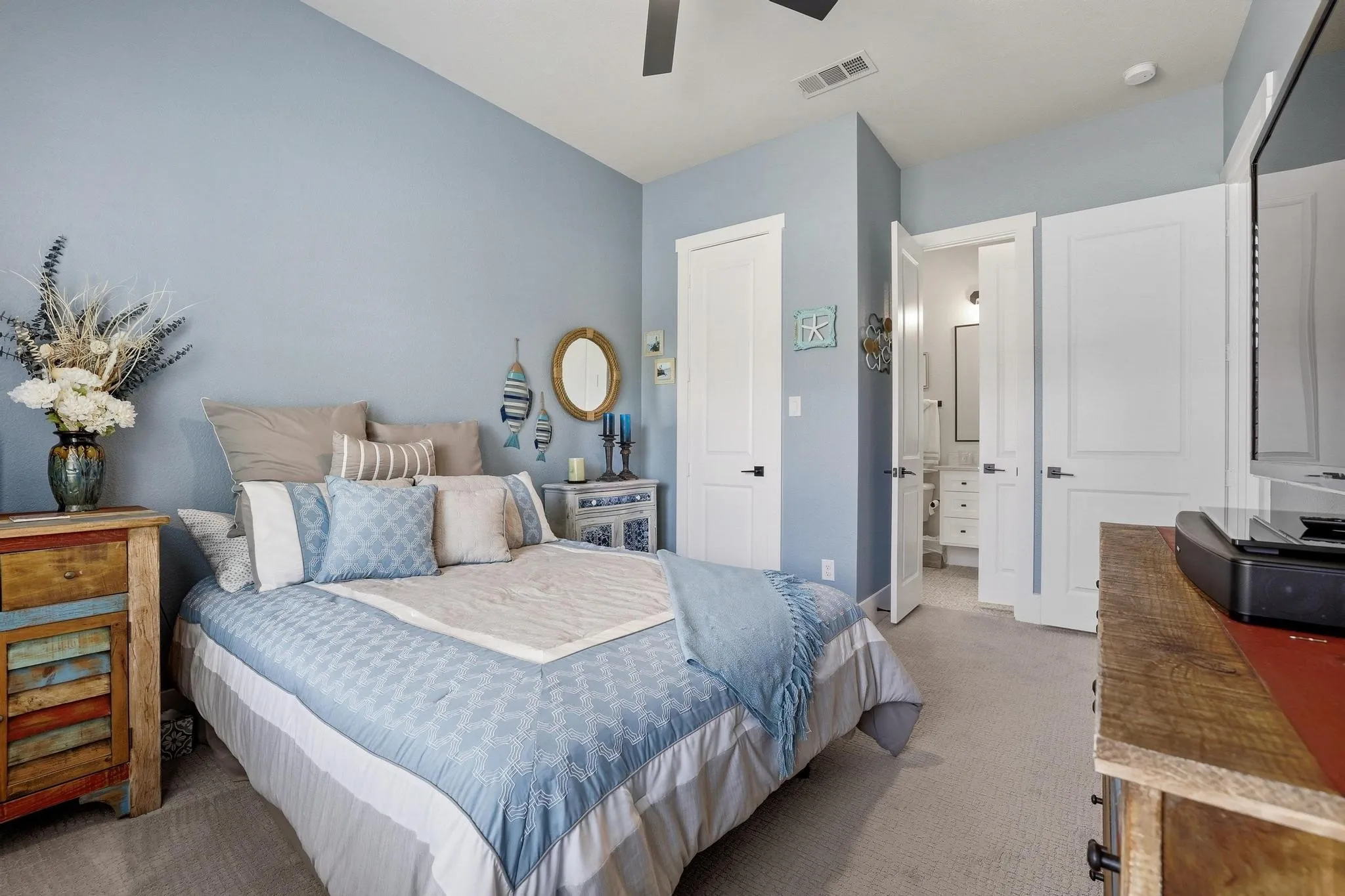 Carpeted bedroom with ensuite bath and a ceiling fan