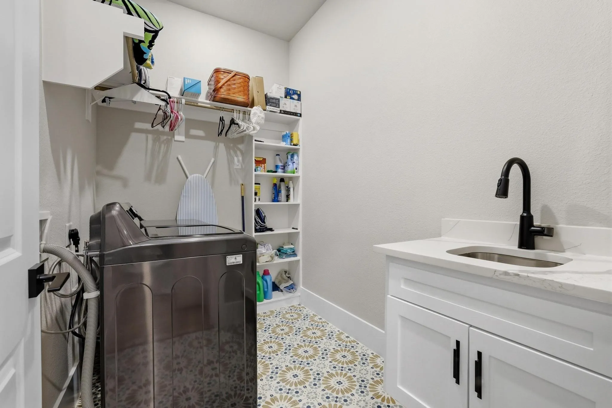 Laundry room featuring washing machine and clothes dryer, cabinet space, and light tile patterned floors