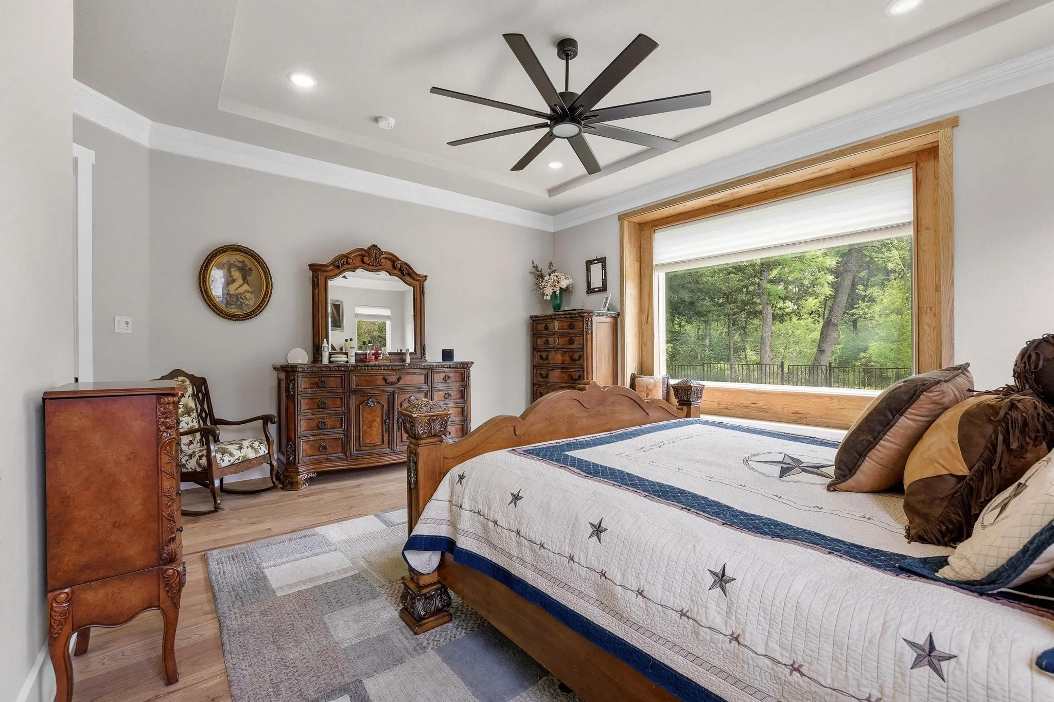 Bedroom with light wood-style floors, crown molding, recessed lighting, ceiling fan, and a tray ceiling