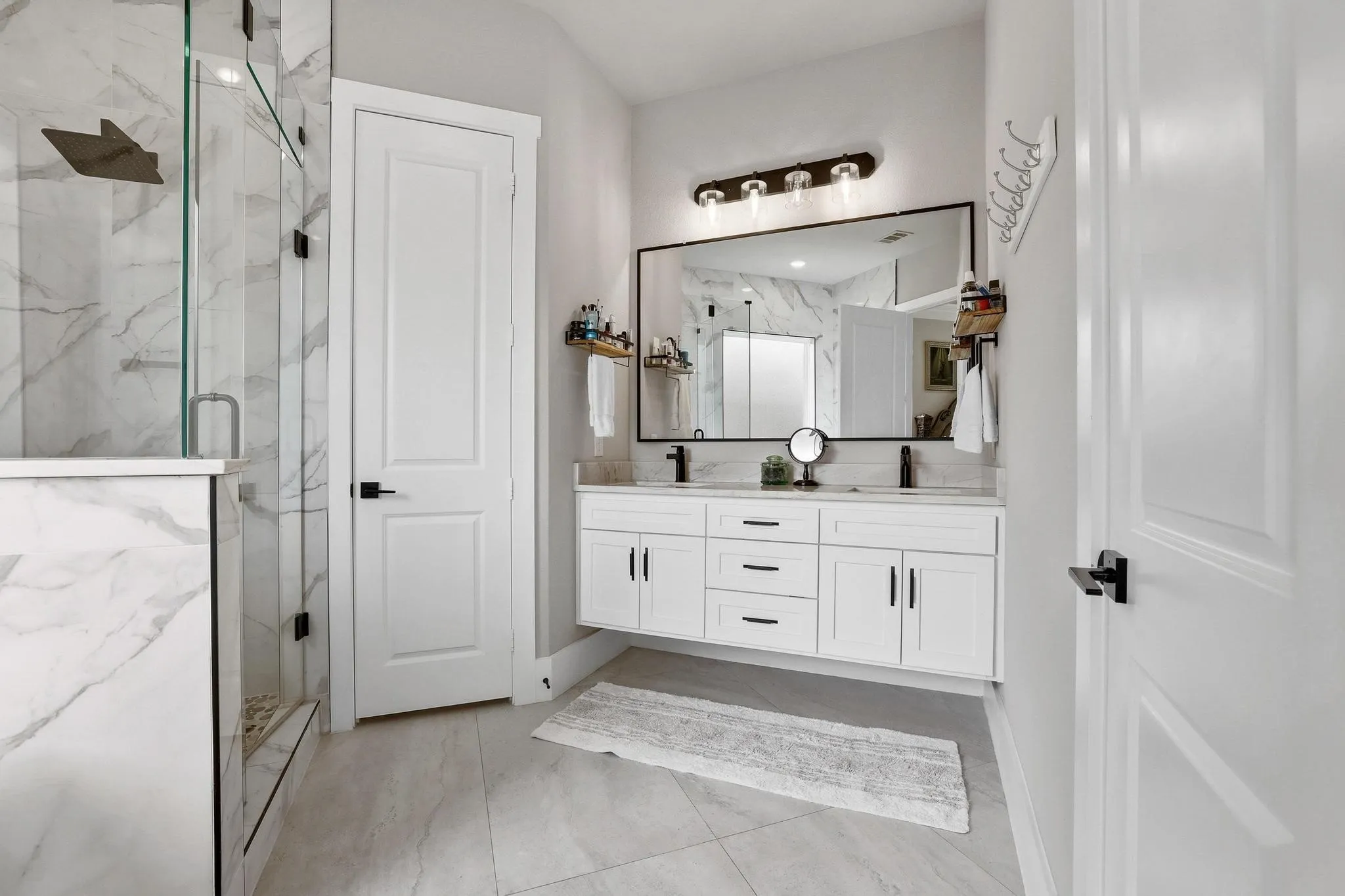 Bathroom with a marble finish shower and double vanity