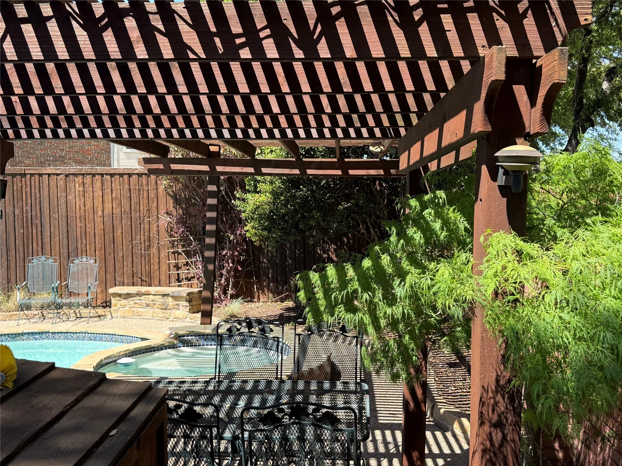 Relaxing pool / spa with a pergola and a patio area