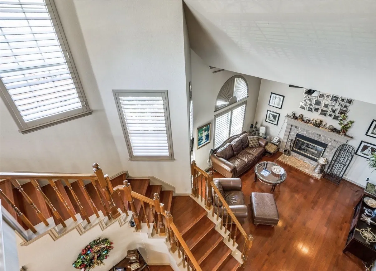 Living room featuring a high ceiling, hardwood / wood-style floors, and a fireplace