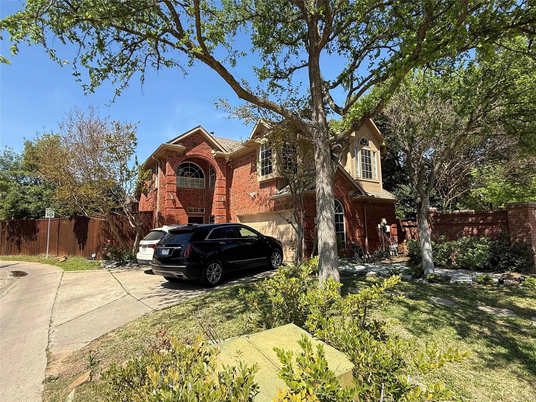 Traditional home with driveway, brick siding, and an attached garage