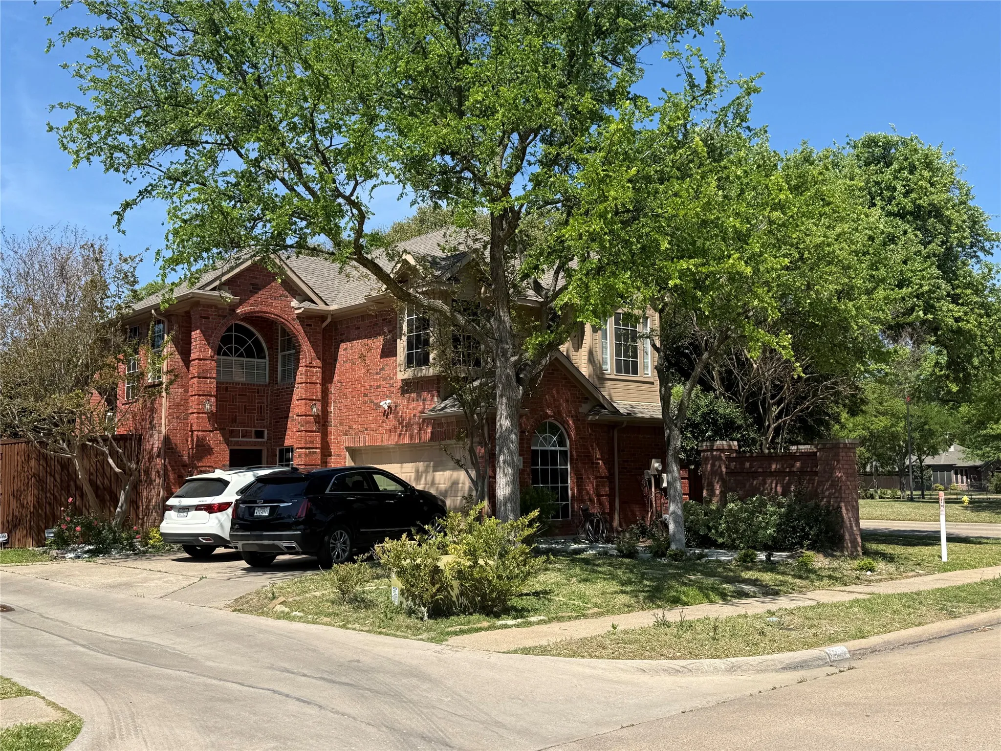 View of front of home featuring brick siding, concrete driveway, and a garage